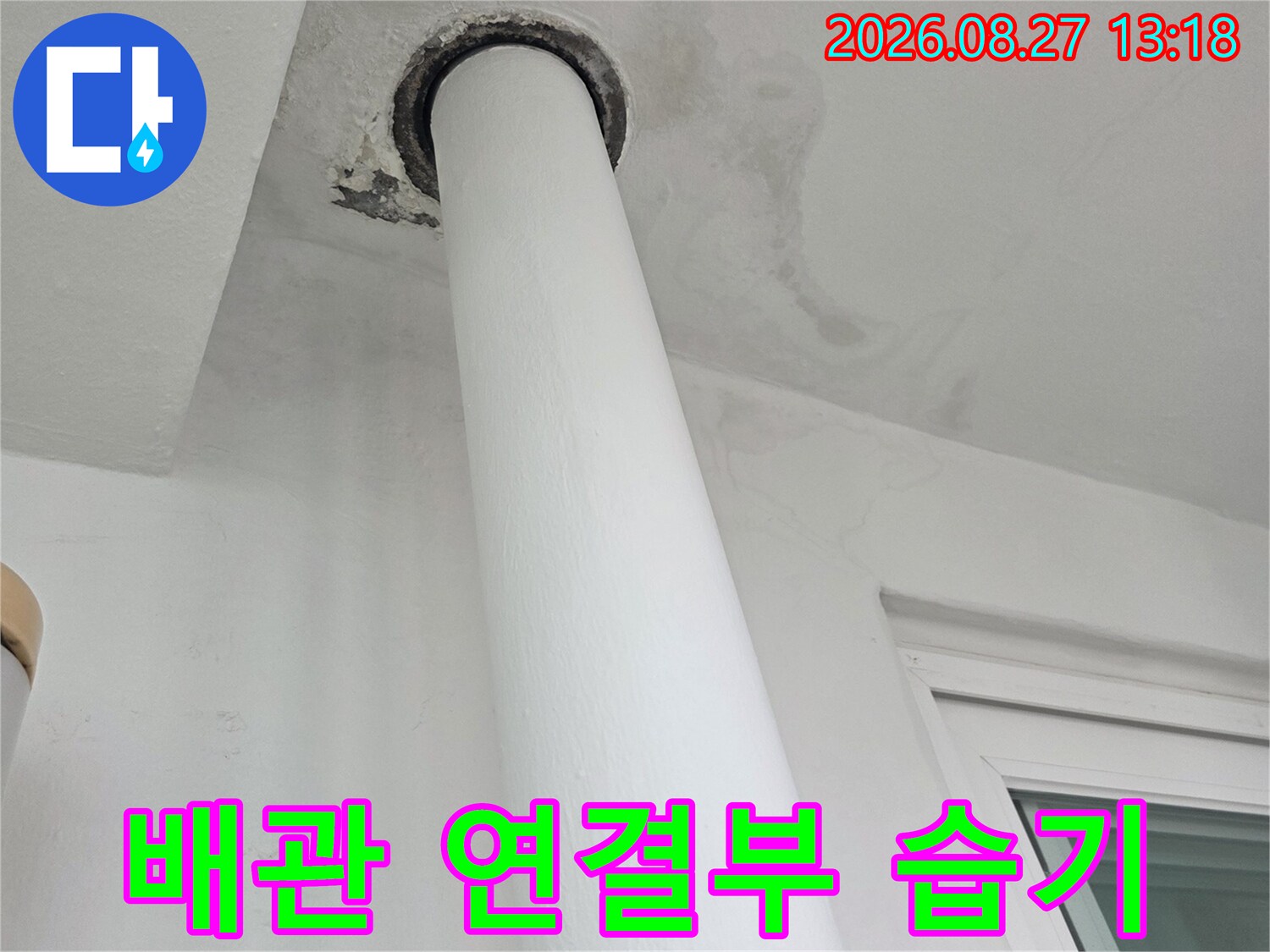 우수관 하단 벽면의 물자국과 젖은 흔적을 근접 촬영한 사진입니다.
