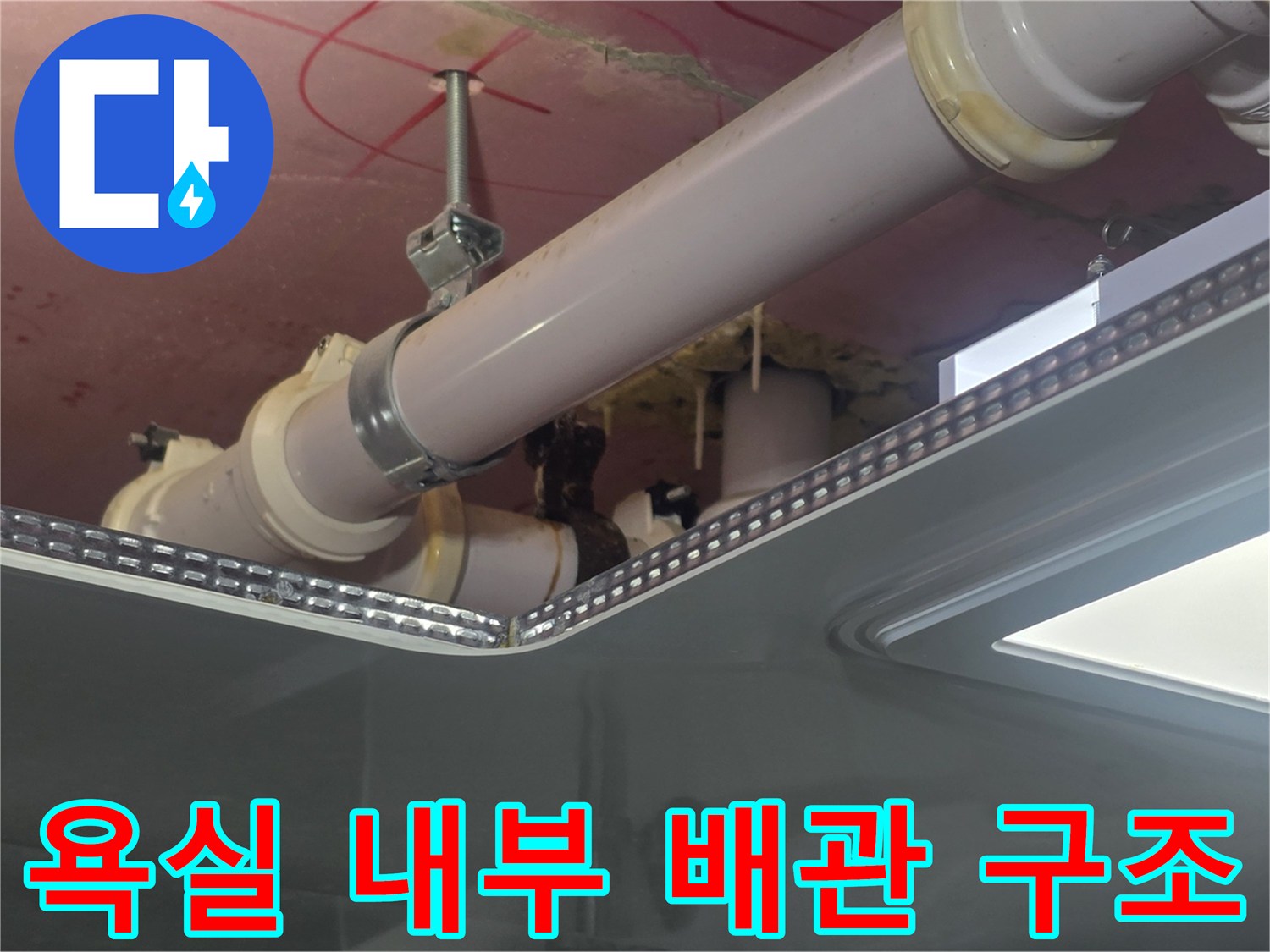 천장 점검구 안쪽의 PVC 배관과 고정 장치를 촬영한 사진
