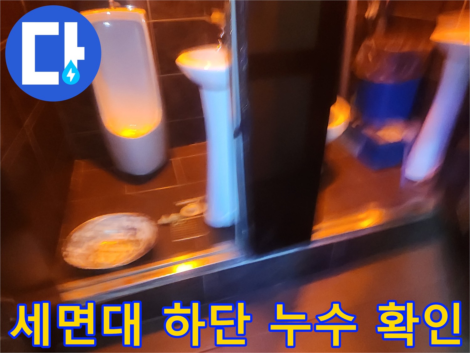 세면대 아래쪽 젖은 타일과 배수구 주변의 누수 흔적 촬영