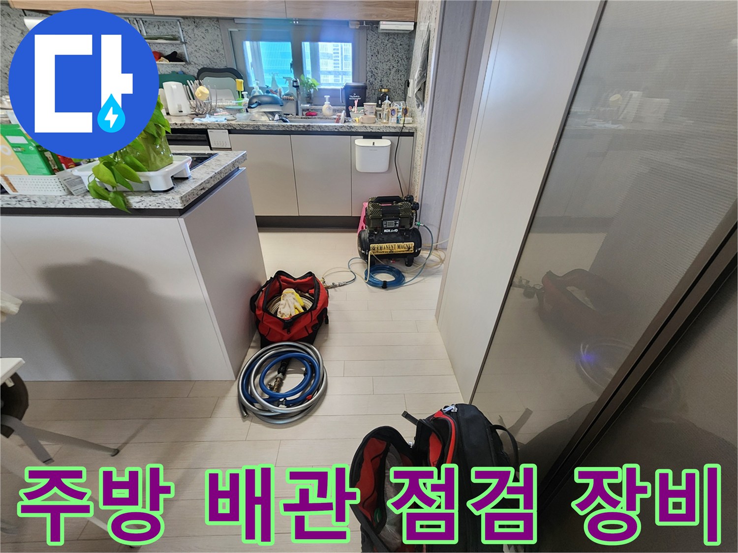 싱크대 하부장 주변에 배치된 배관 점검용 디지털 압력계와 호스들