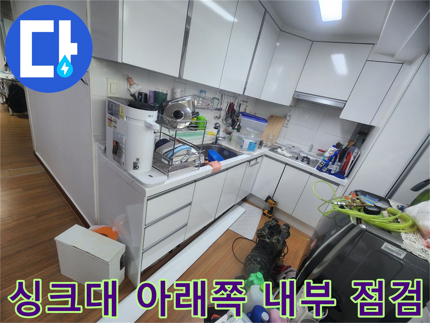 주방 싱기대 하부장 내부에 배치된 용품과 배관의 모습입니다.