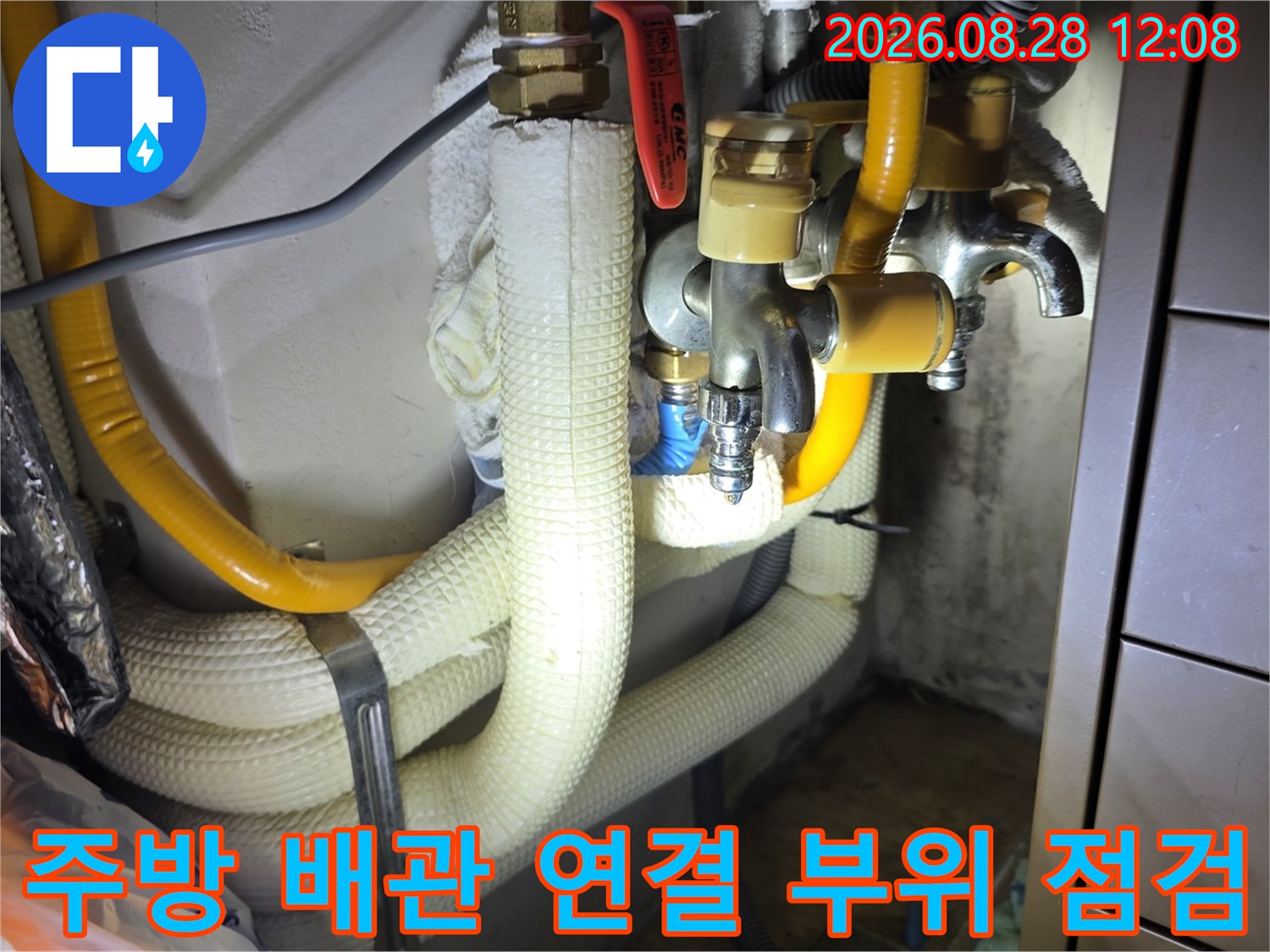 흰색 보온재와 노란색 호스가 있는 싱크대 하부 배관의 상세 모습