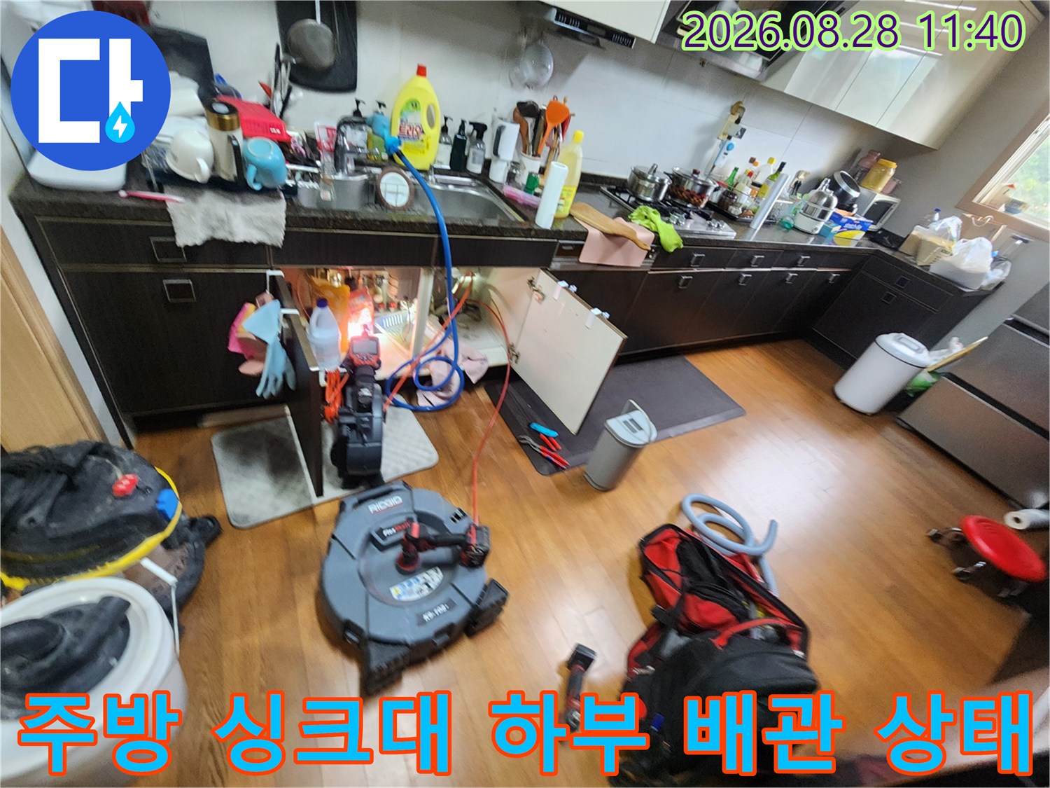 싱크대 아래쪽 배관 연결 부위와 누수 점검용 장비 배치 상황