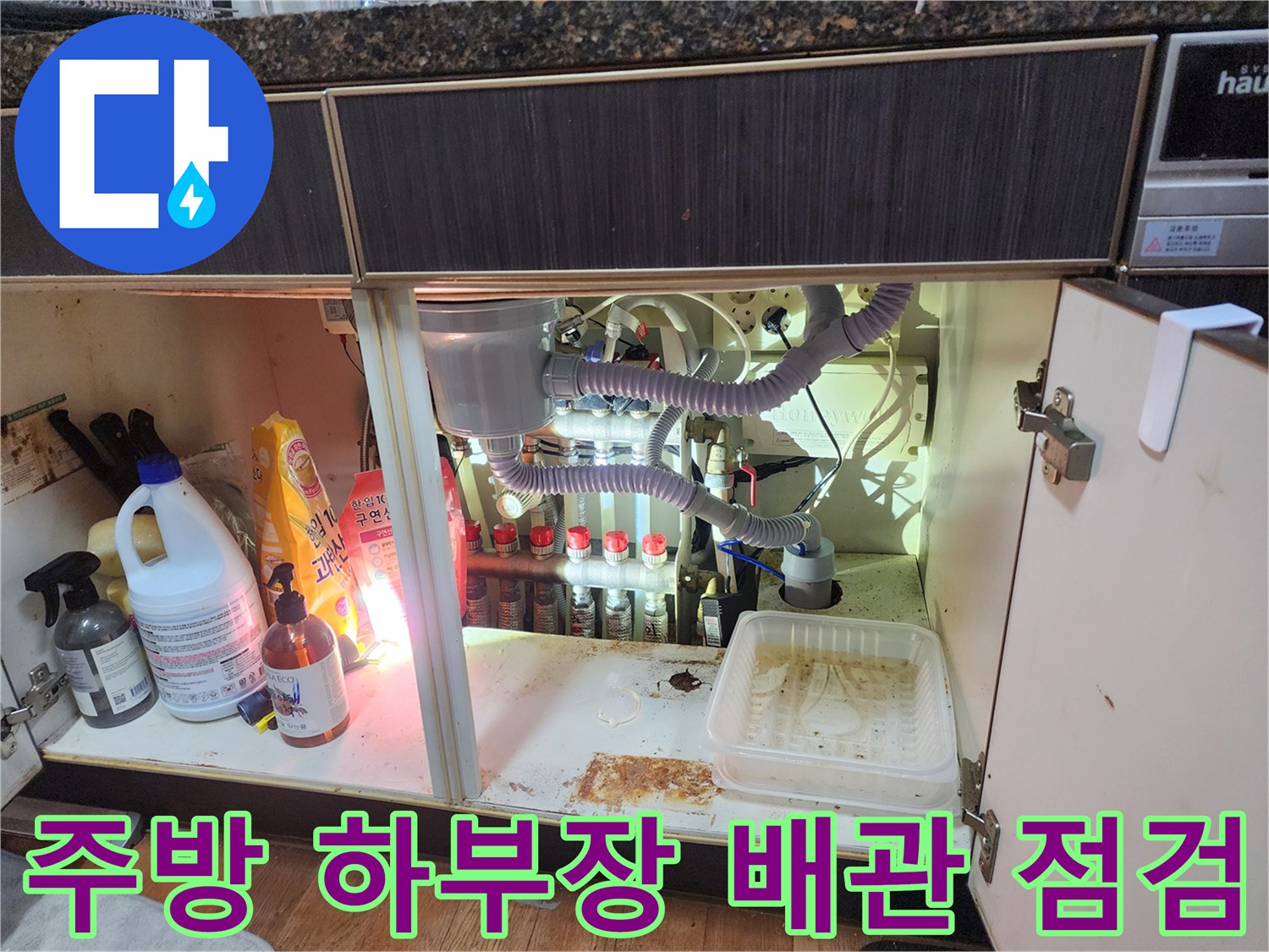 싱크대 아래쪽 배관 연결 부위와 주변 세정제들