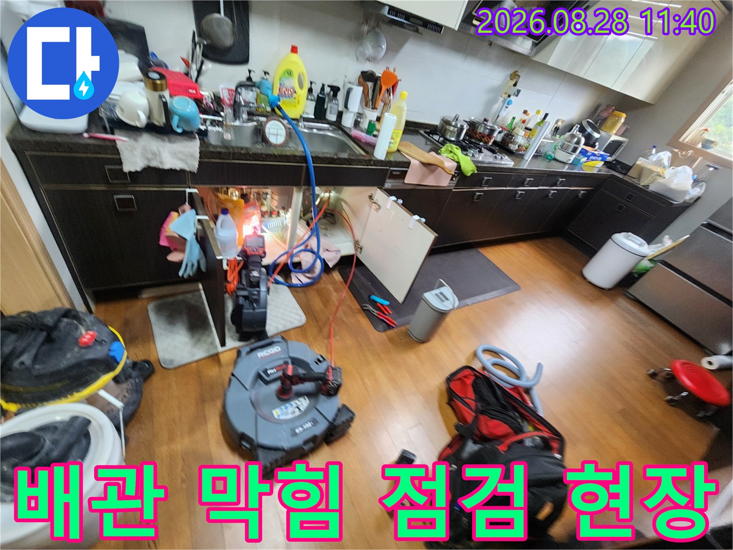 싱크대 하부 배관의 누수 지점을 찾기 위해 장비를 사용 중인 모습