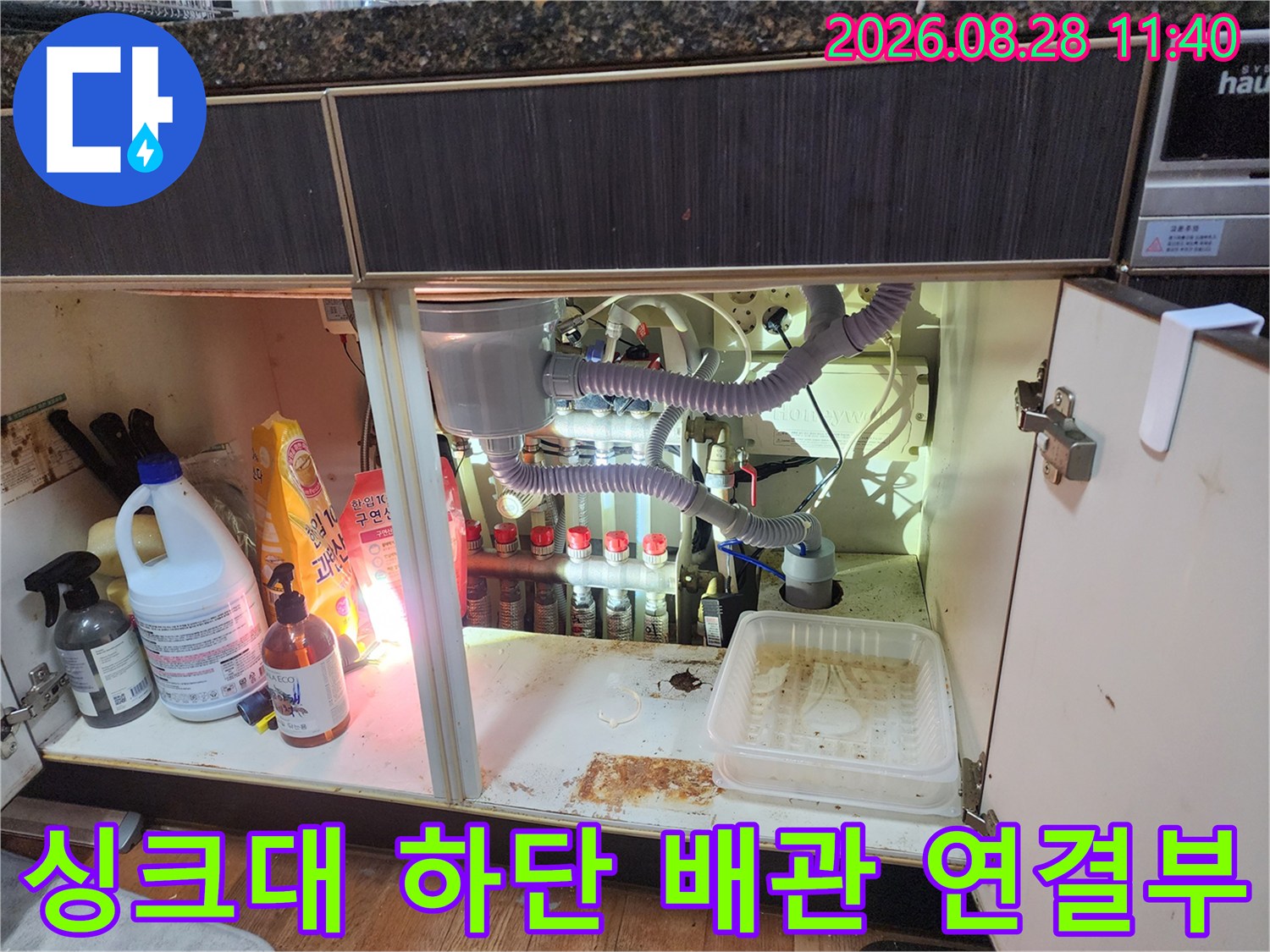 싱크대 하부장 내부의 다양한 배수 호스와 연결 부위 상세 모습입니다.