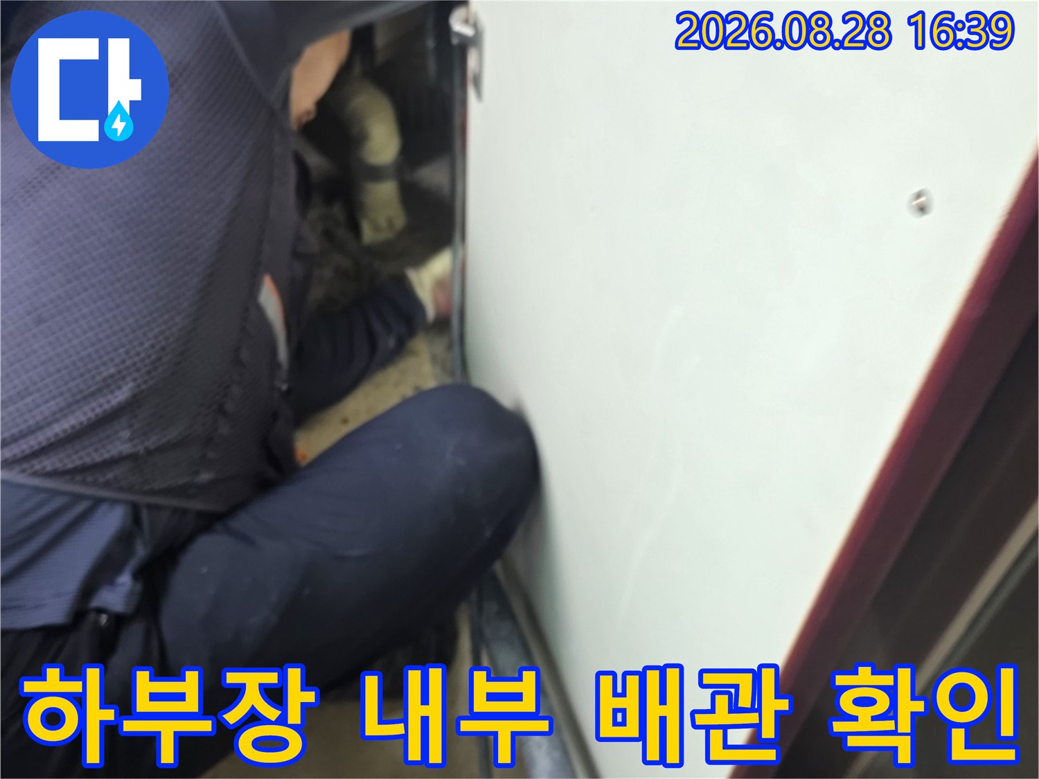 좁은 싱크대 하부 공간에서 배관 누수 여부를 조사하고 있습니다.