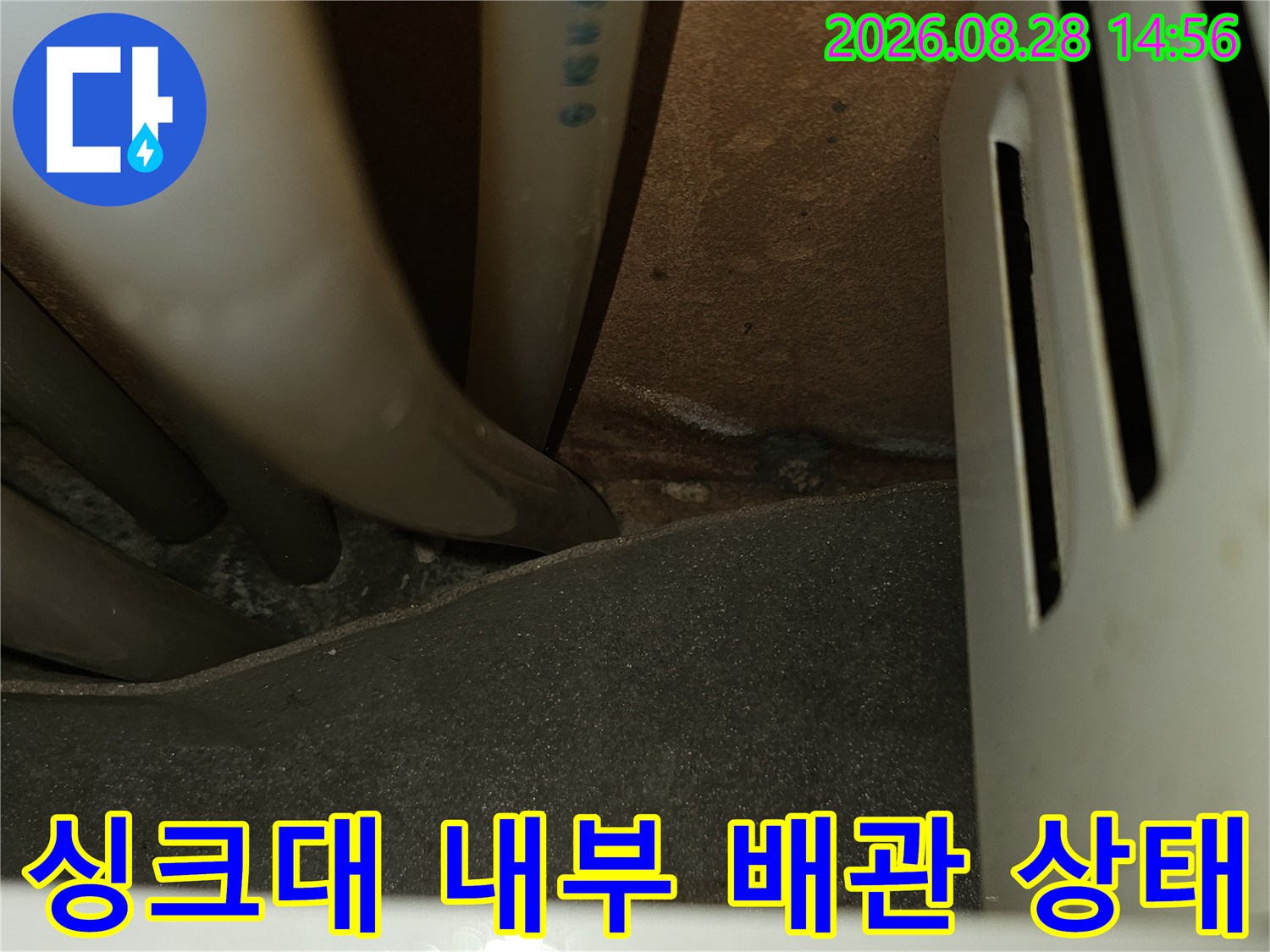 싱크대 하단부의 복잡한 수도 및 보일러 배관 연결 구간 점검 상황