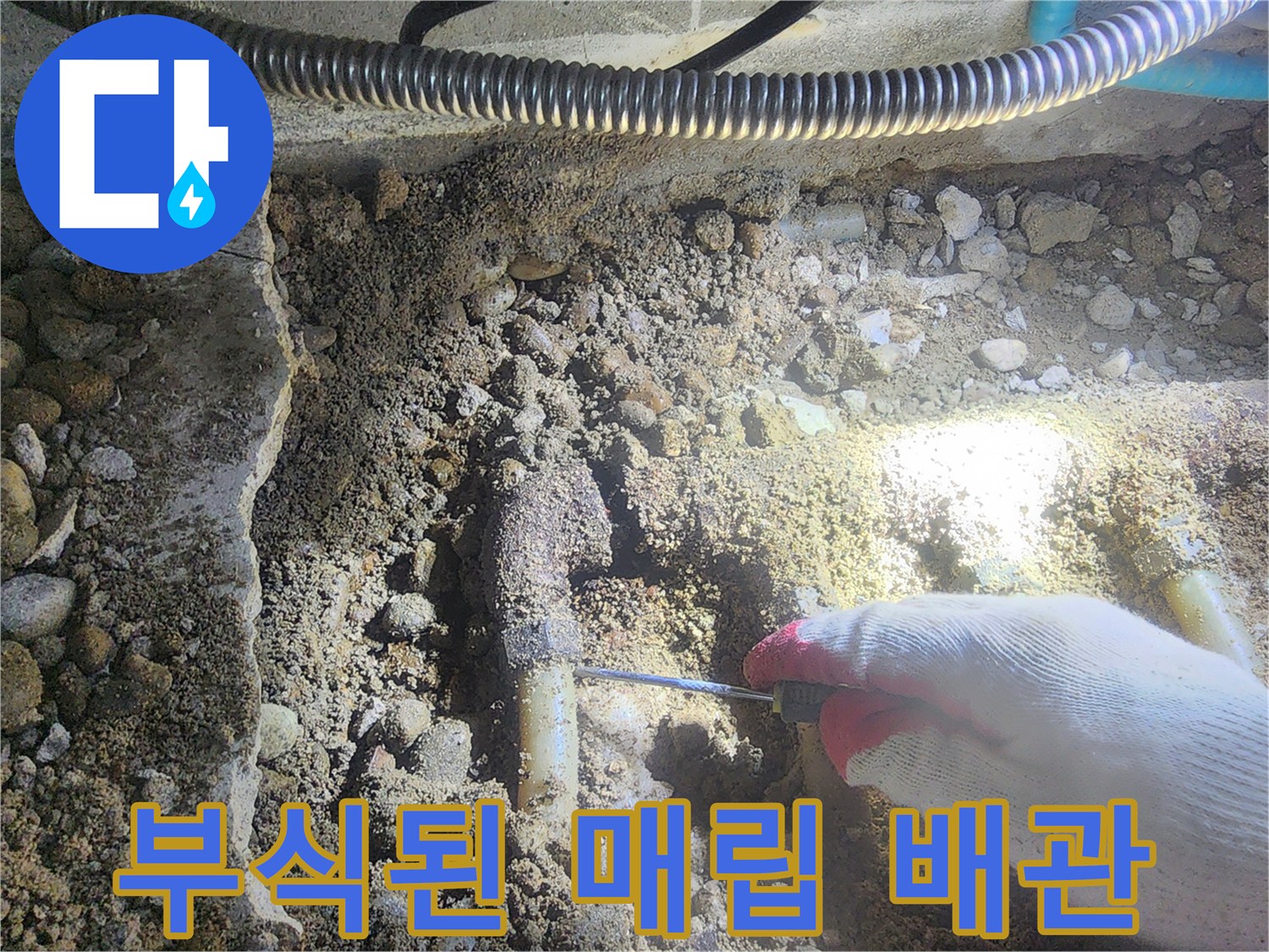 흙과 자갈 속에 드러난 부식된 금속제 분배기 모습