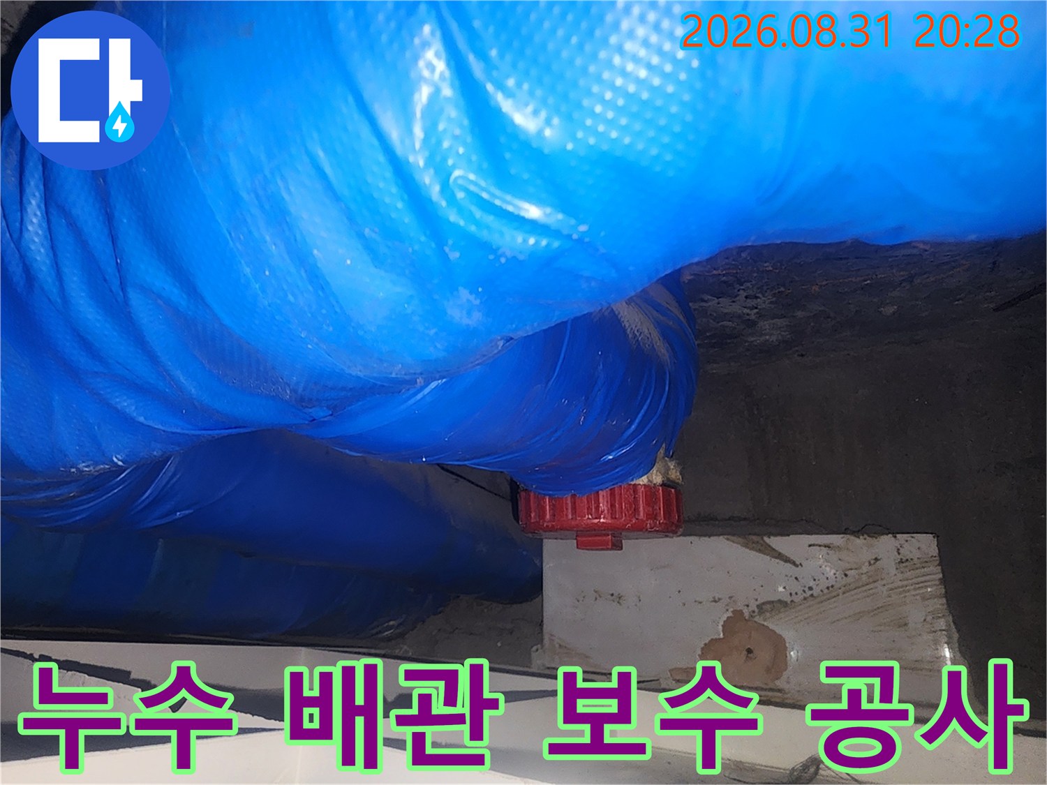 파란색 비닐로 감싸진-하수관 주변의 누수 보수 현장 사진입니다.