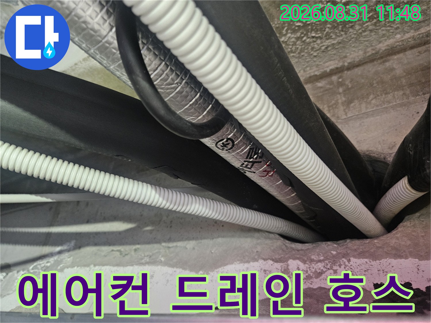 천장 내부의-하얀색 주름 배관과 검은색 보온재 배관 모습입니다.