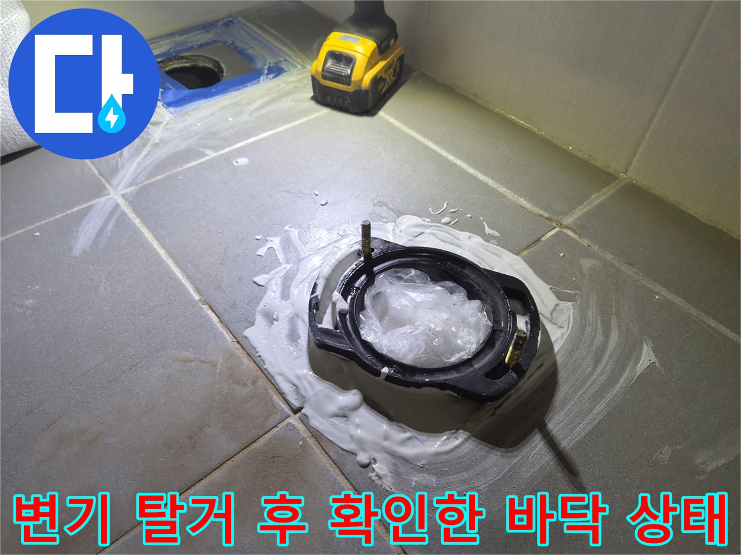 변기를 들어낸 자리의 타일 사이로 고여 있는 물과 오염된 방수층 상태를 보여주는 사진입니다.