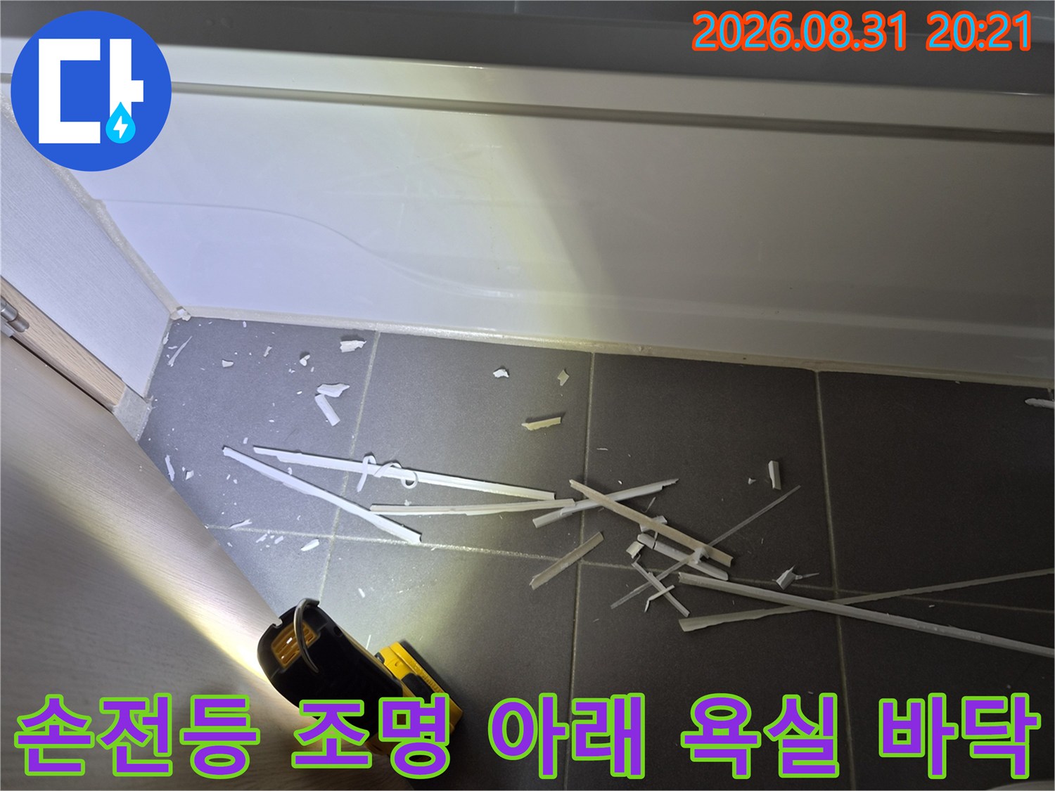 손전등으로 비춘 욕조 하부의 타일 틈새와 주변 환경 점검