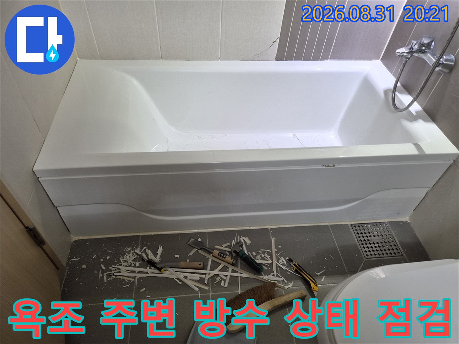 천안 불당동 화장실의 하얀색 욕조와 바닥 작업 도구들