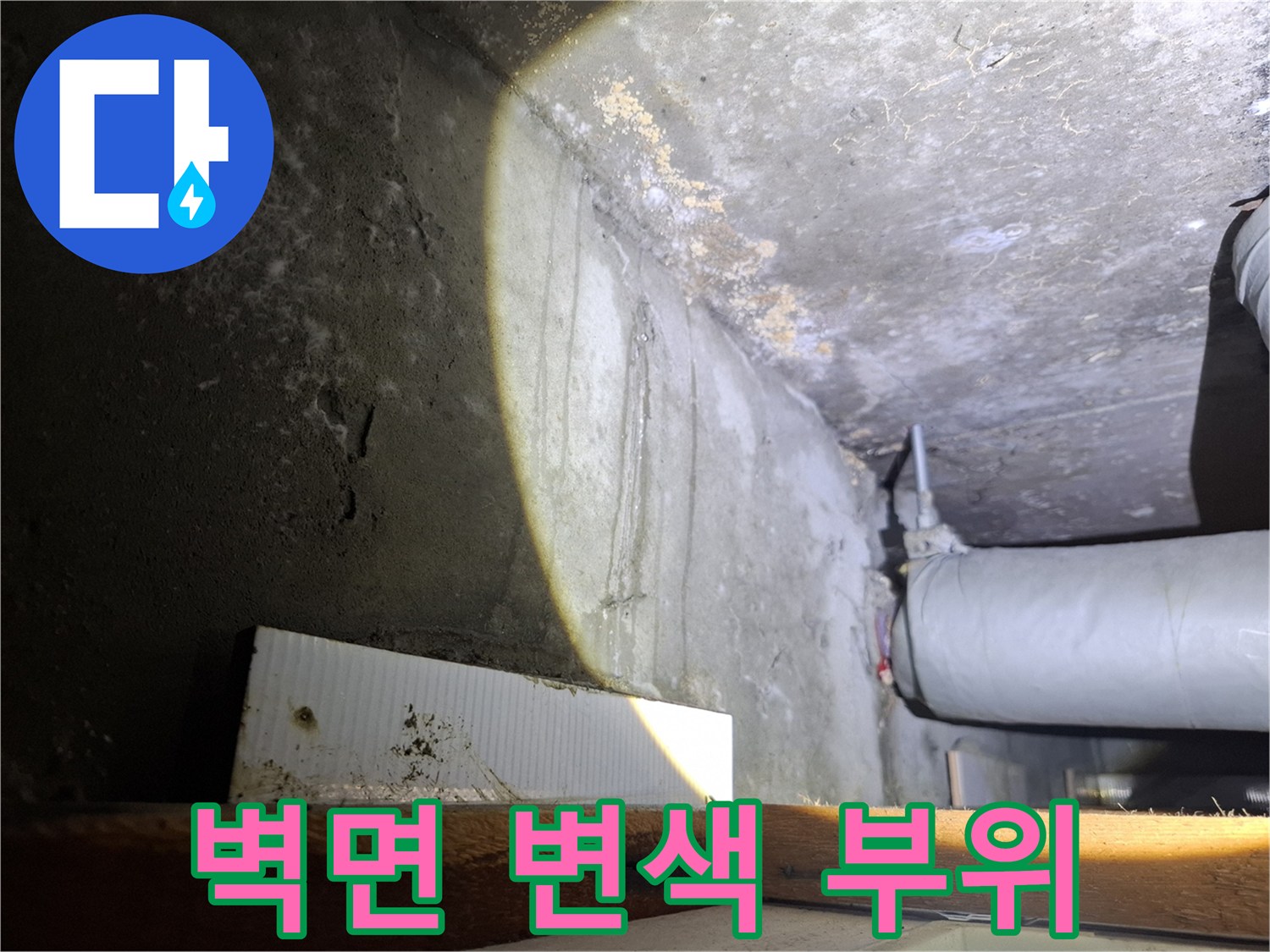 천장 근처의 젖은 벽면과 노출된 배관 라인