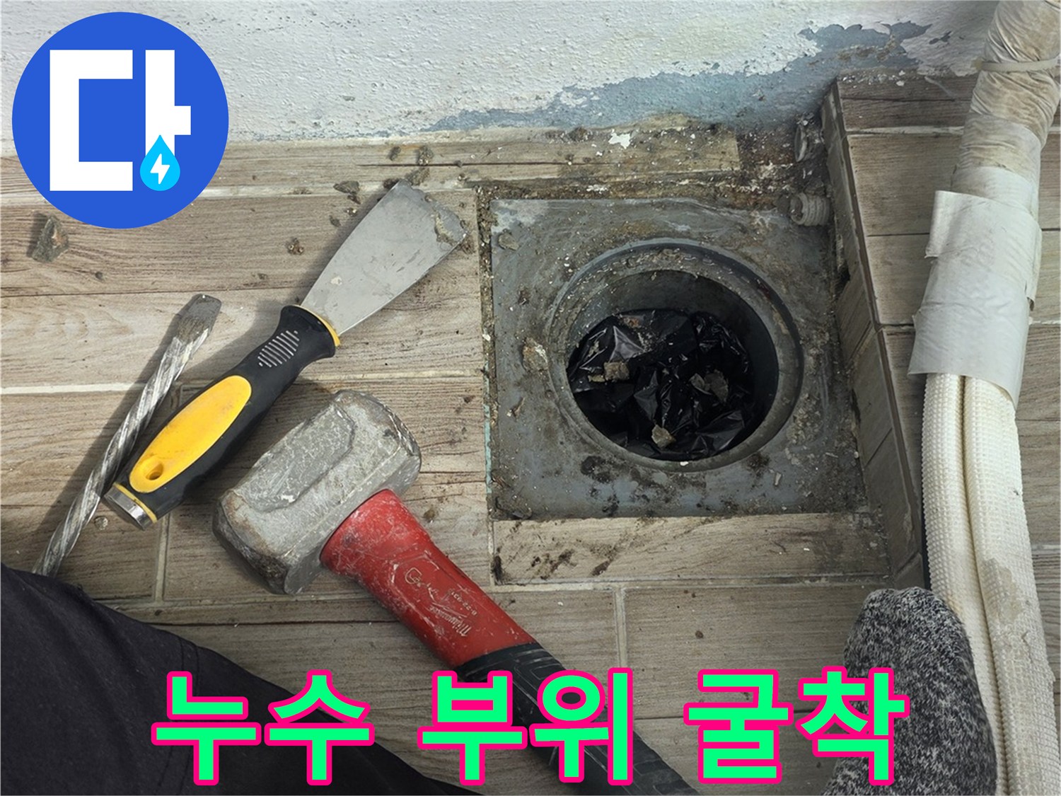 타일이 제거된 바닥 배관 주변과 작업용 수공구들