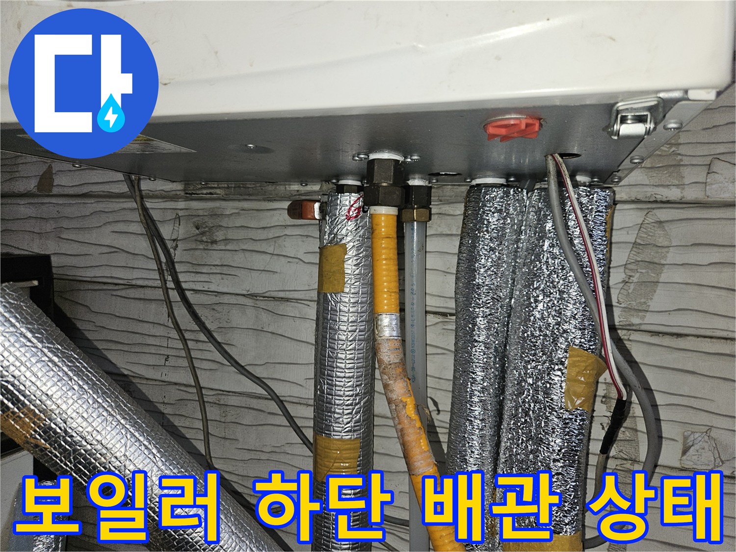 보일러-하단에-연결된-은박-보온재-배관-및-전선-모습