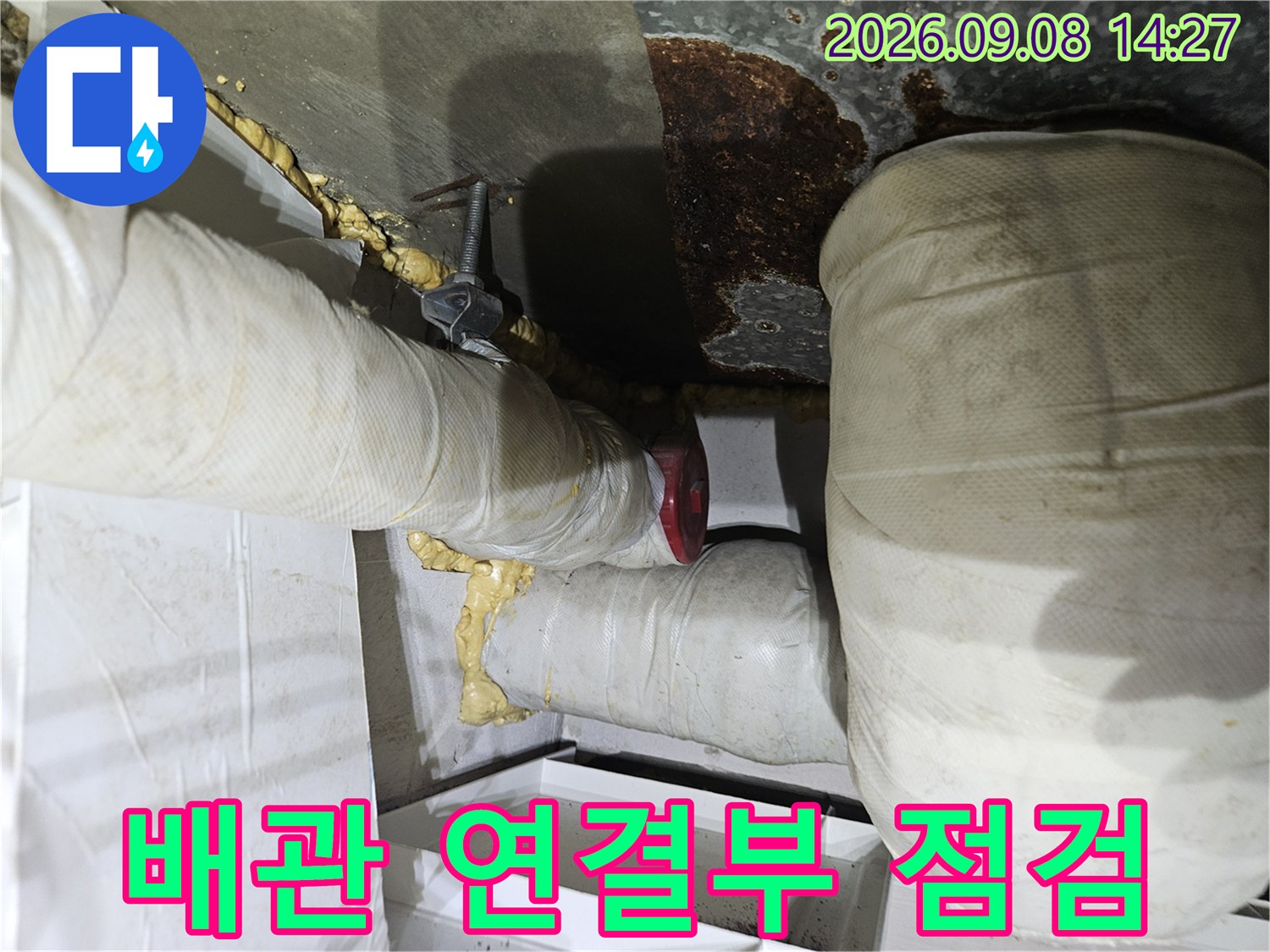 하얀색 보온재로 감싸진-배관의-연결 부위를-상세히-점검하는-모습