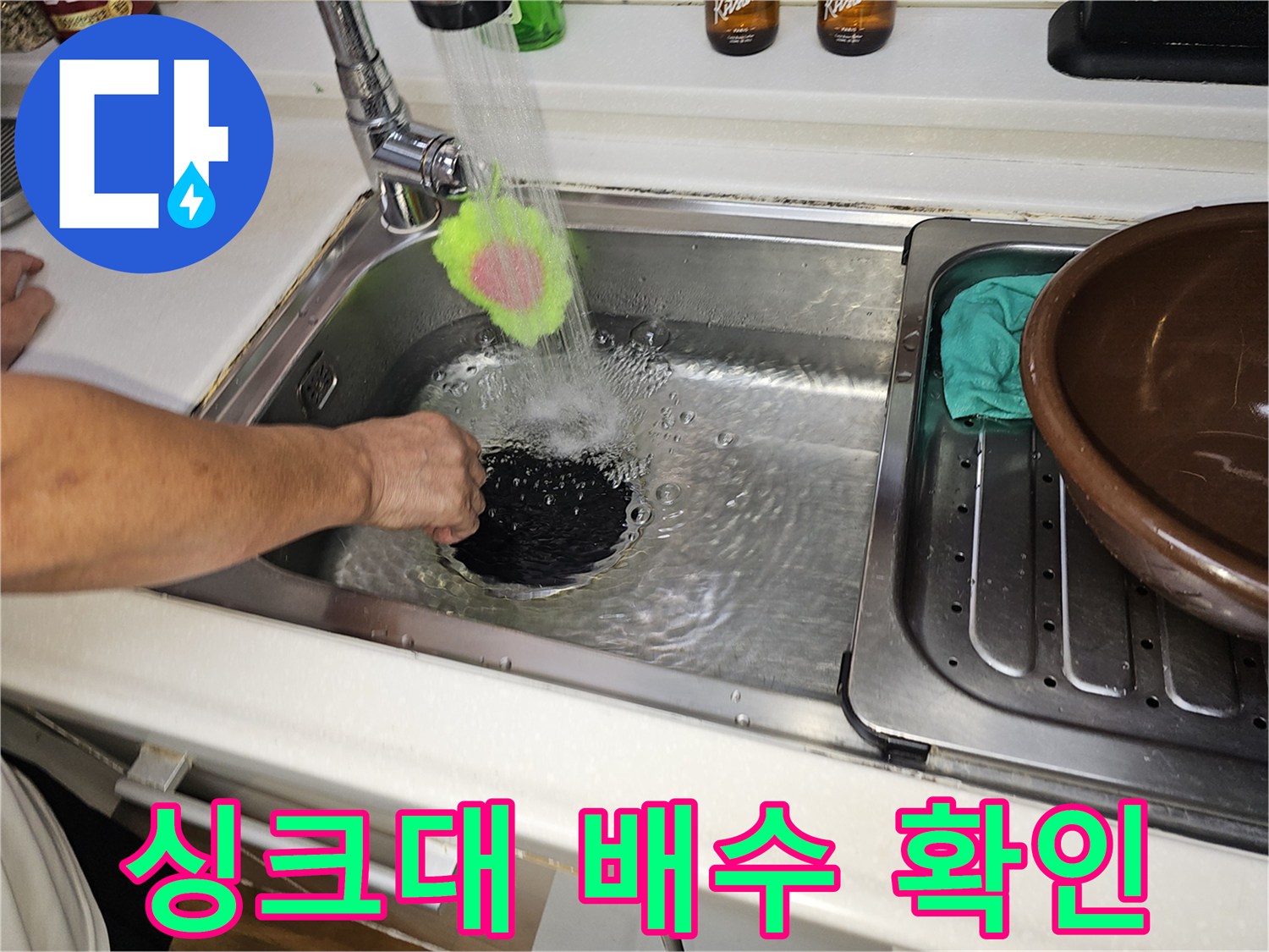 수전에서 나오는 물줄기가 싱크대 배수구로 유입되는 장면