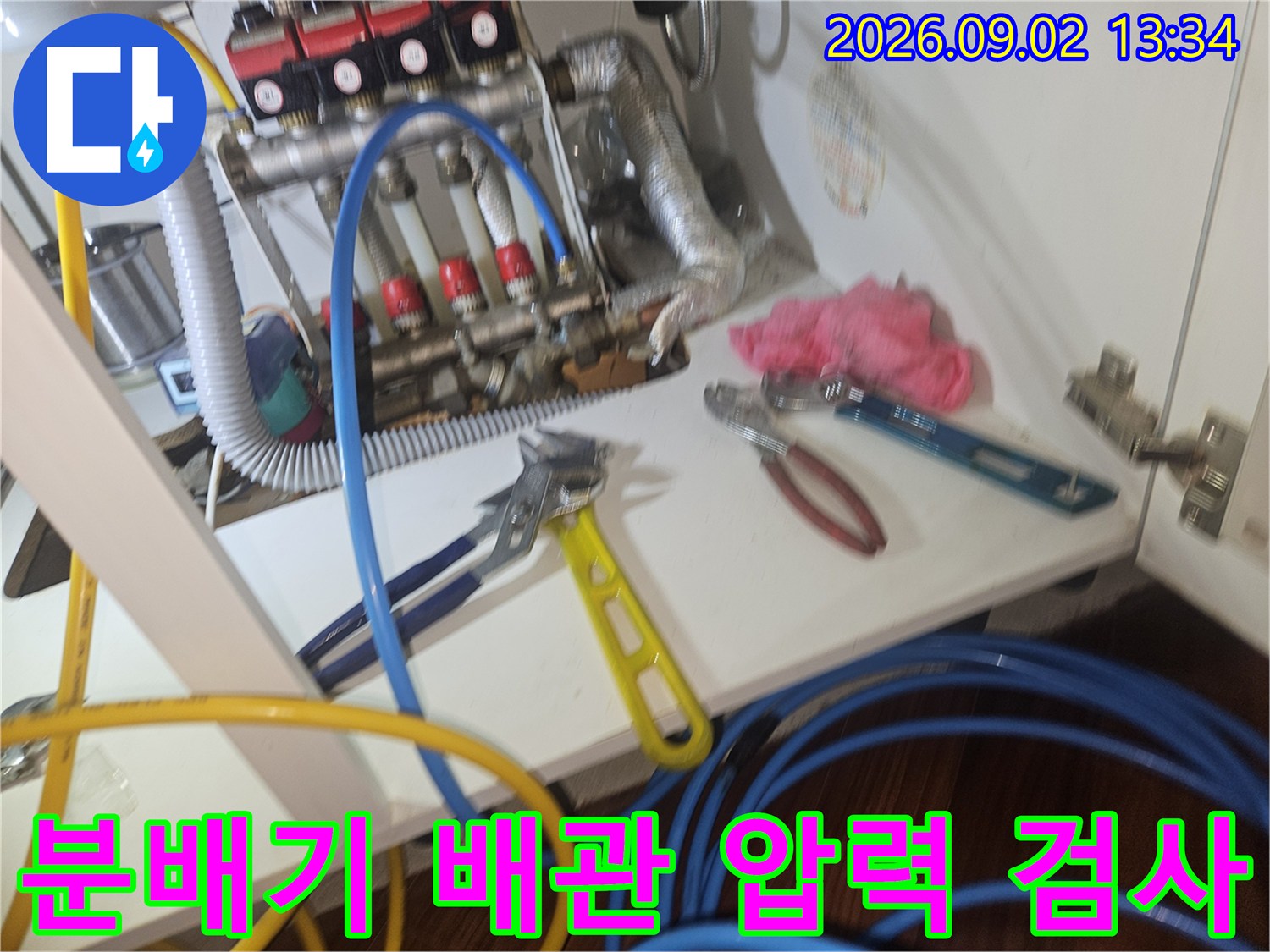 보일러 분배기에 연결된 테스트 호스와 작업용 공구들
