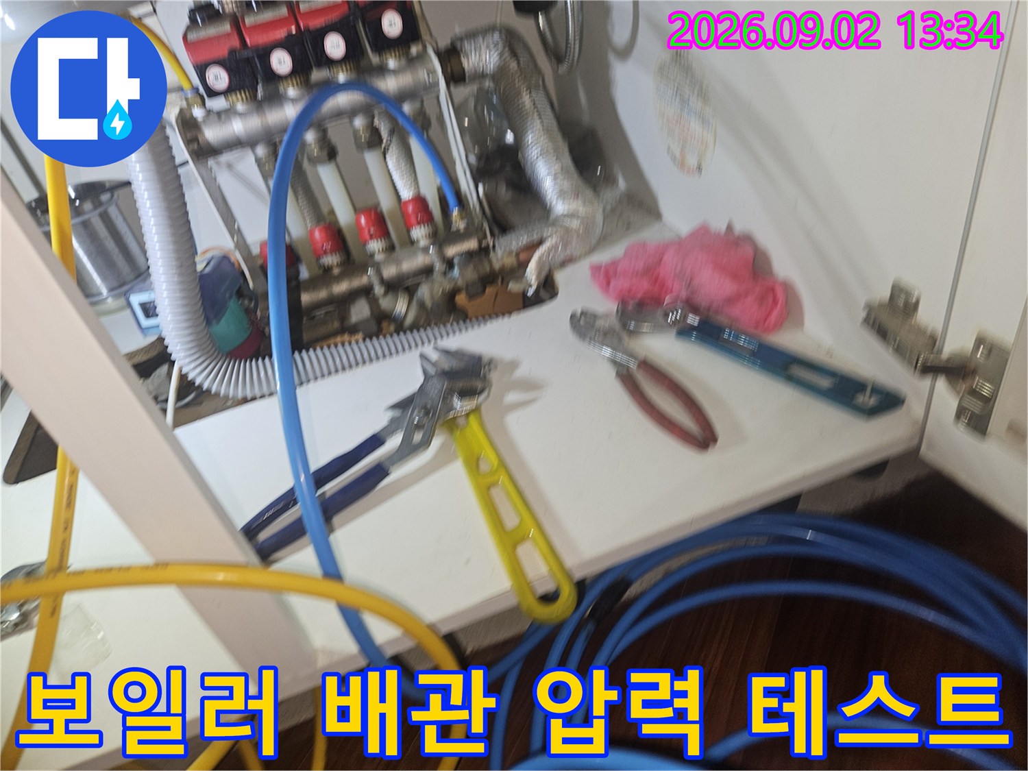 분배기에 연결된 파란색 호스와 측정용 장비가 놓인 작업 모습