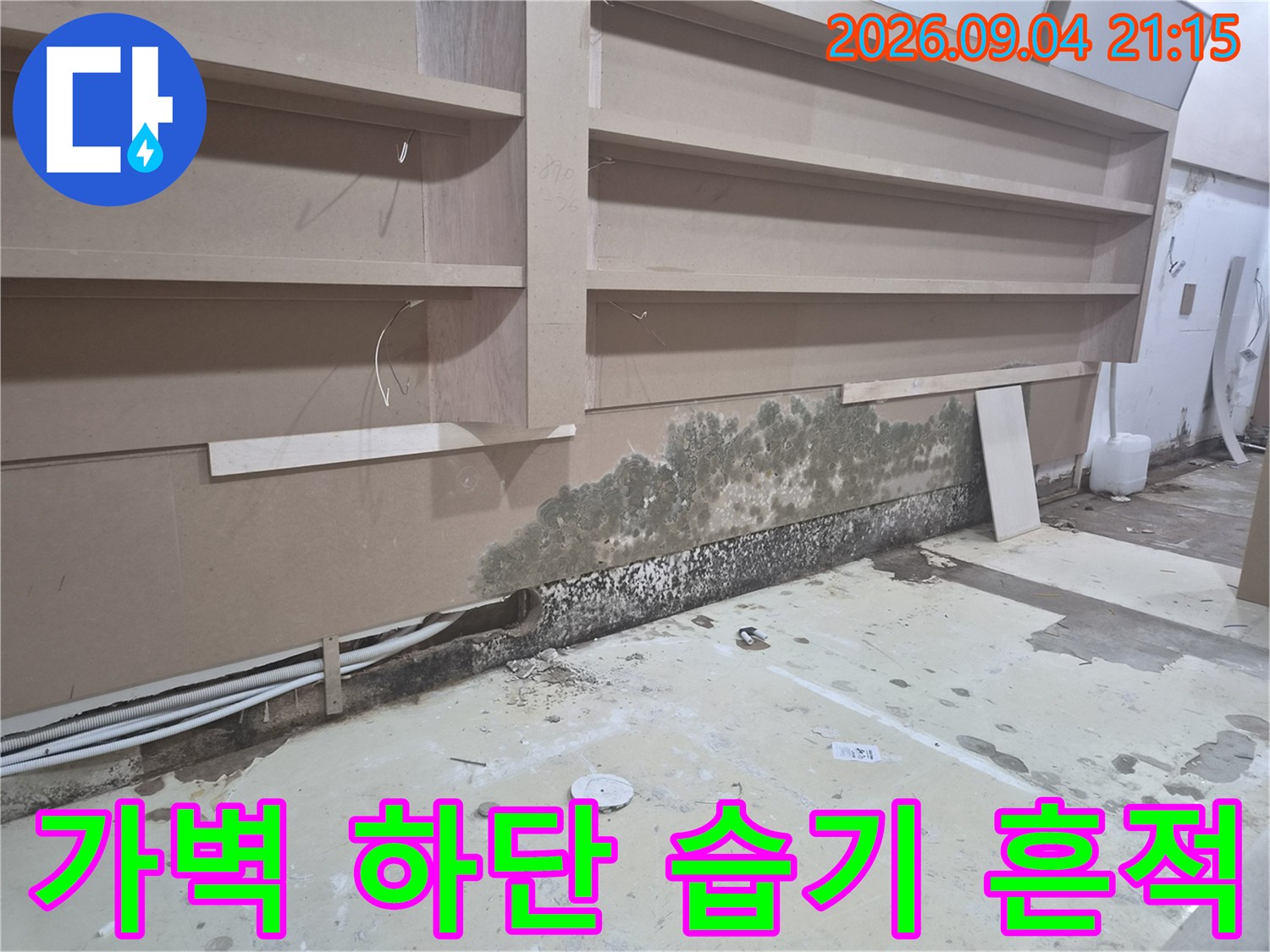 상가 가벽 하단 마감재 주변의 곰팡이와 누수 오염 부위