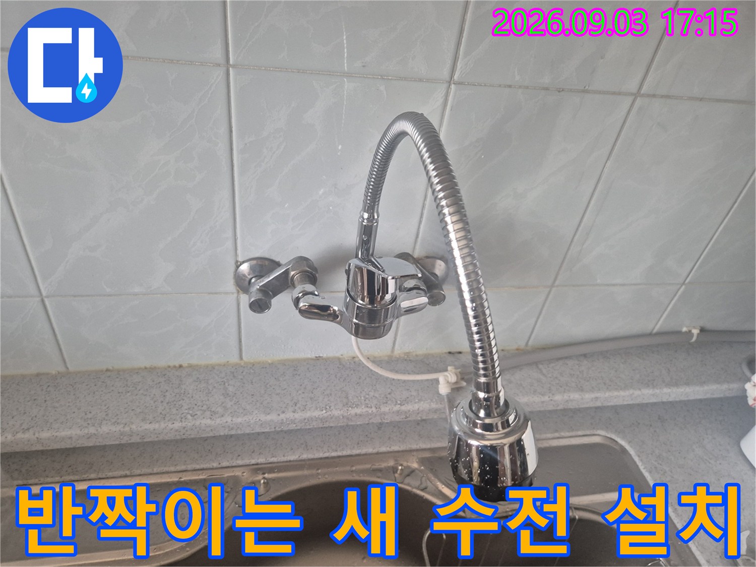 싱크대 볼에 새로 장착된 은색 자바라형 수전입니다.