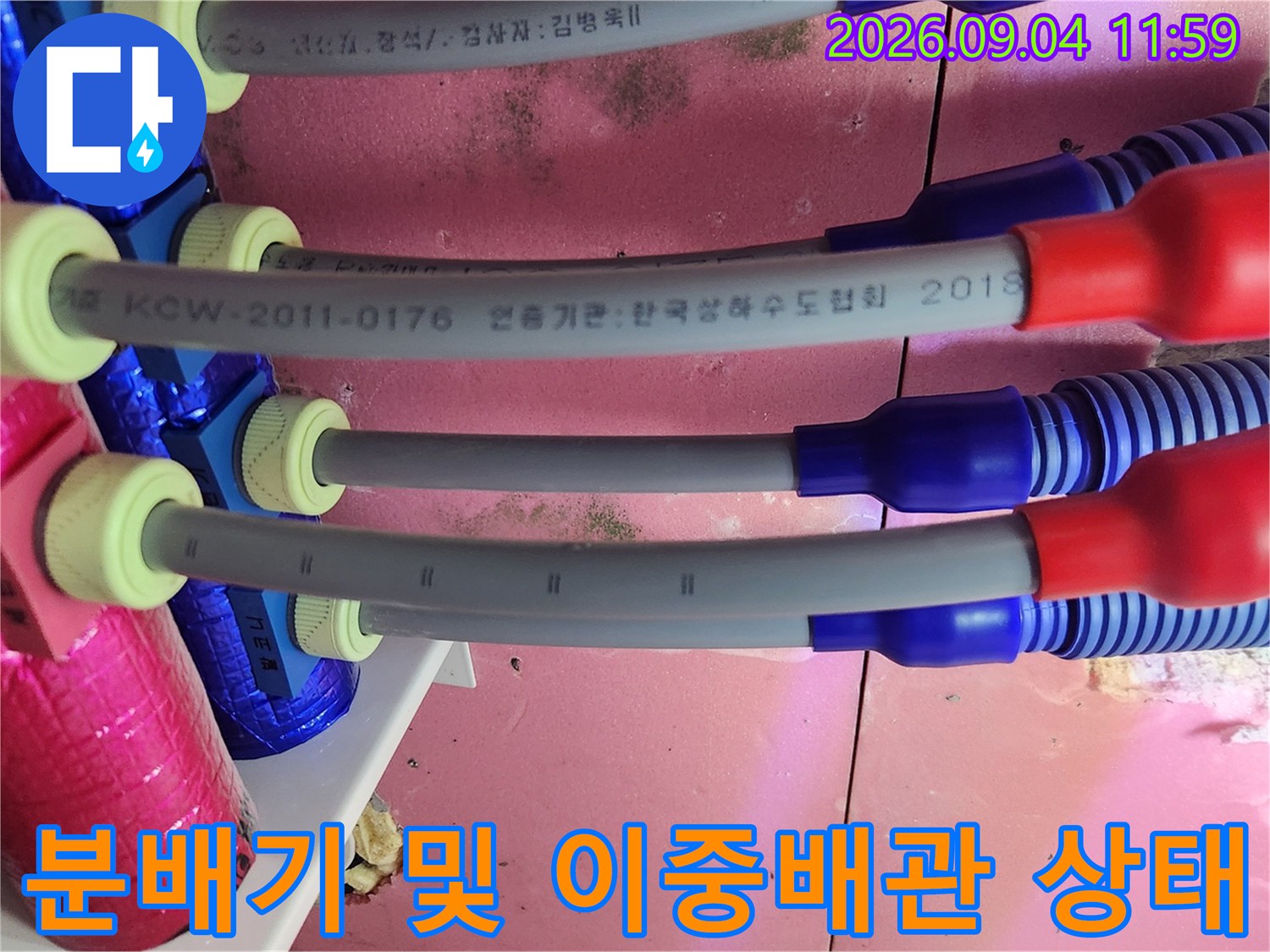 천장 내부의 분홍색 보온재 배관과 파란색 보호 캡이 있는 배관 모습