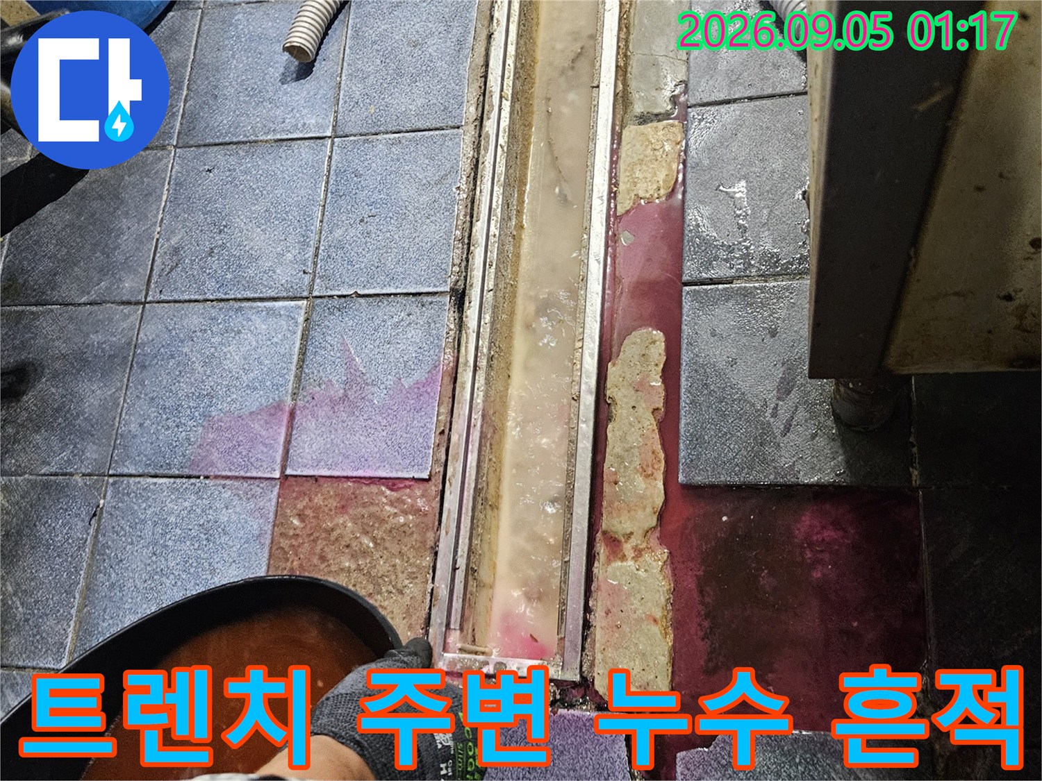 광진구 자양동 주방 트렌치 유가 주변의 붉은색 누수 흔적과 타일 틈새 상태를 보여주는 사진입니다.