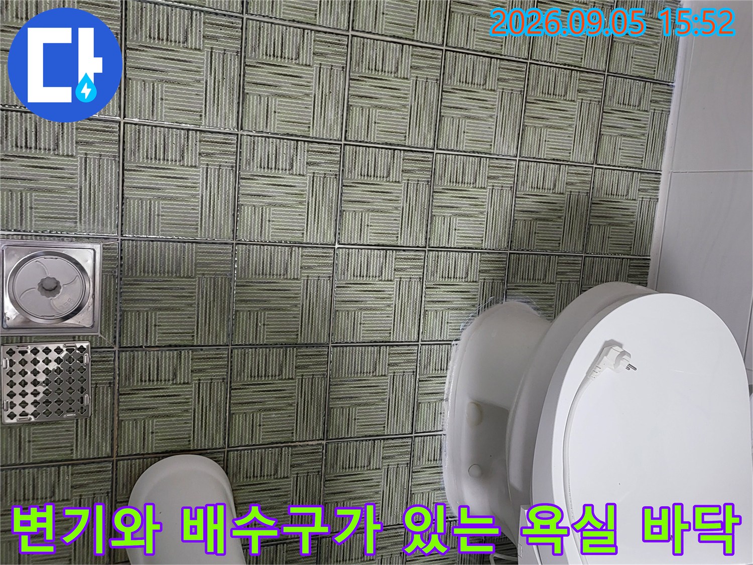 화장실 변기 아래쪽 타일과 스테인리스 배수구 상세 사진