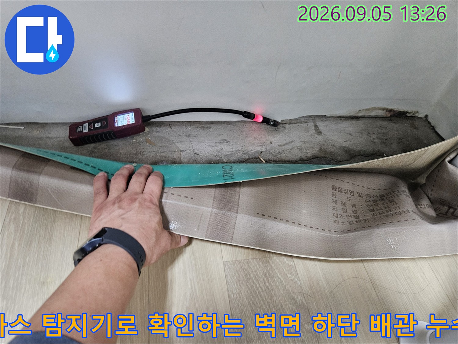 벽면 틈새로 드러난 배관 부근을 가스 탐지기를 사용하여 정밀하게 조사합니다.