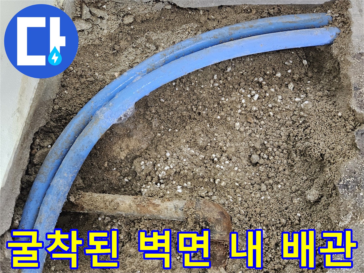 벽면을 파내어 드러난 파란색 PB관과 부식된 관