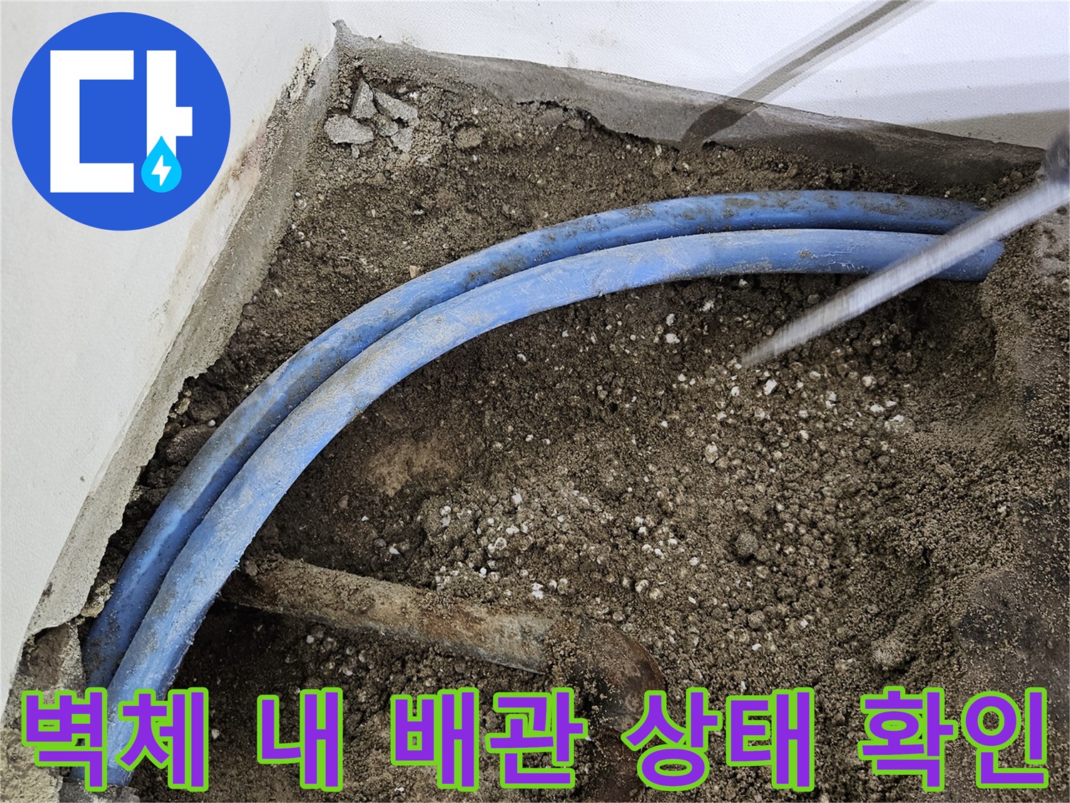 파헤쳐진-벽면-안쪽의-파란색-배관과-젖은-흙