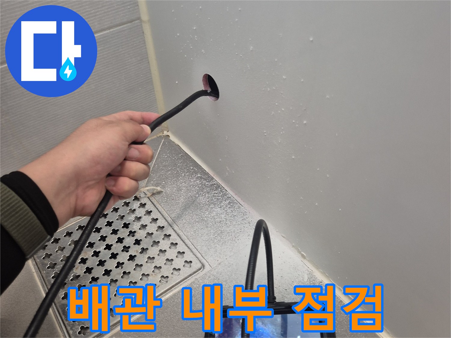 욕실 배수구 근처의 배관 상태를 내시경 장비로 정밀하게 조사하는 모습