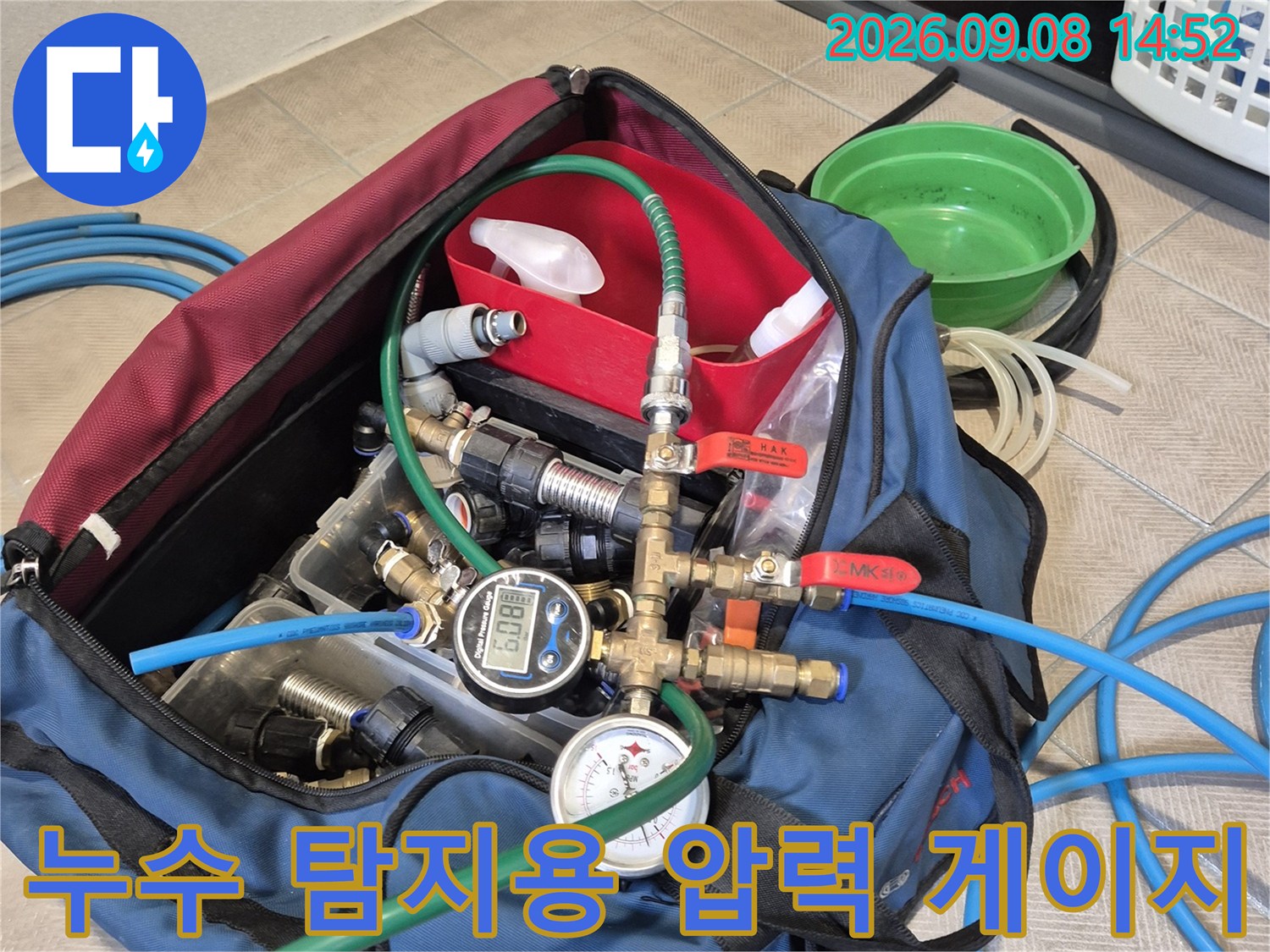배관 압력을 측정하는 디지털 게이지와 연결된 밸브 및 호스 구성