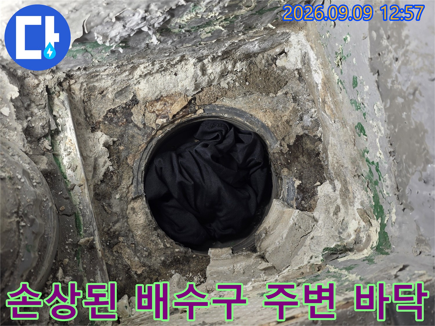배수관 주위의 젖은 시멘트와 파손된 마감재 모습
