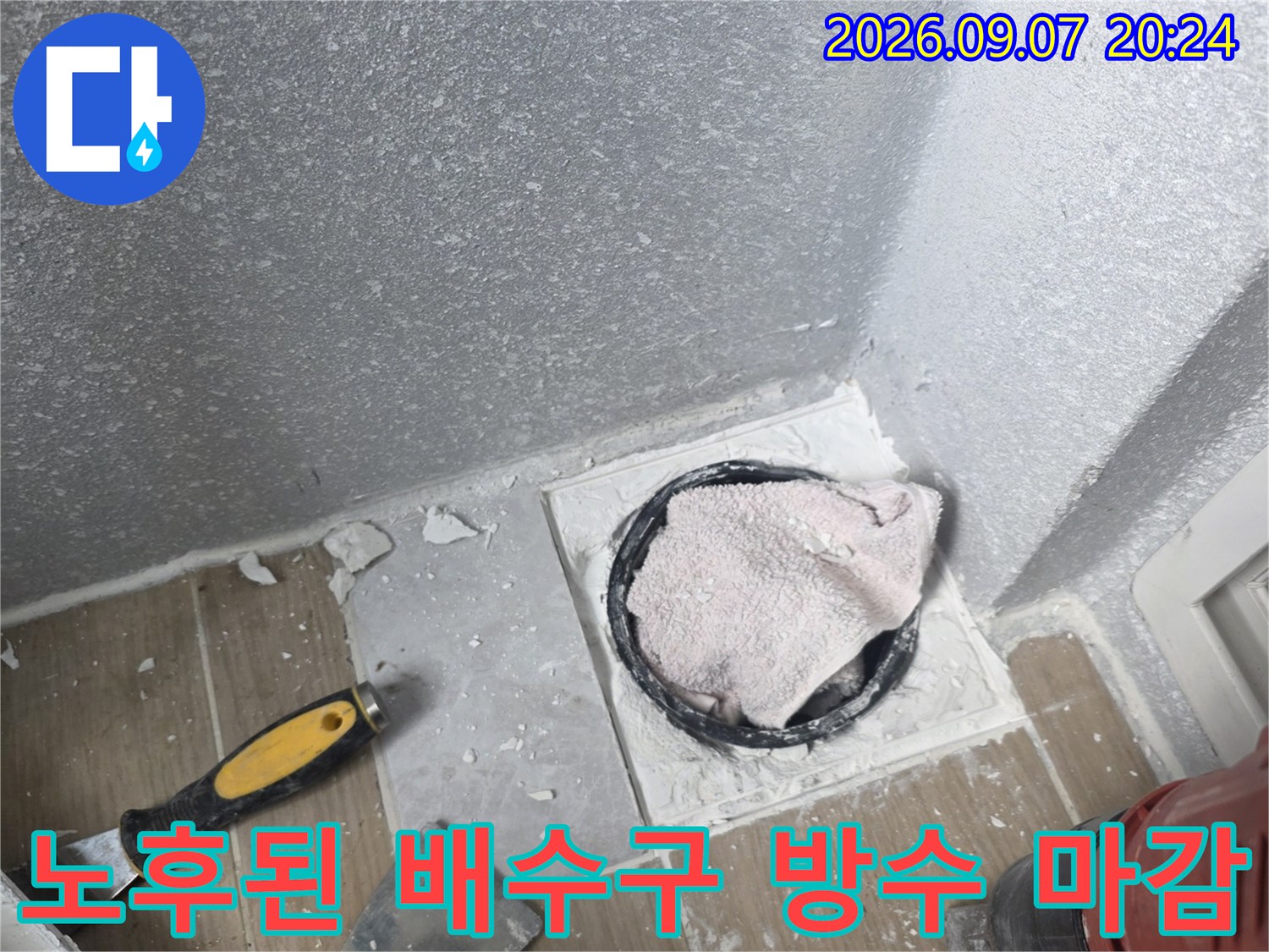 배수구 주변의 낡은 방수층과 노출된 배관 연결 부위 모습