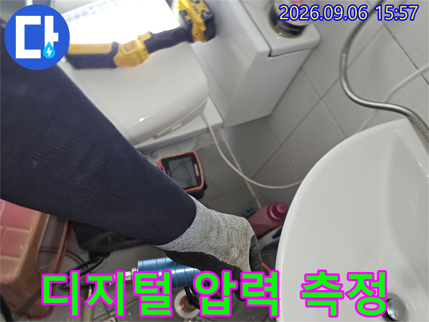 작업자가 장갑을 착용하고 배관에 연결된 압력계를 점검하고 있습니다.