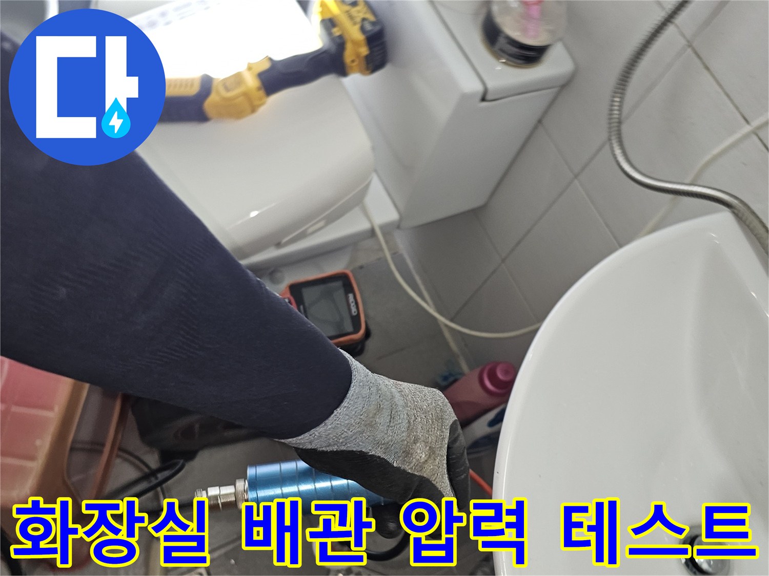 화장실 세면대 아래에서-배관의 기밀성을 확인하기 위해-압력 측정 장비를 연결한 모습입니다.