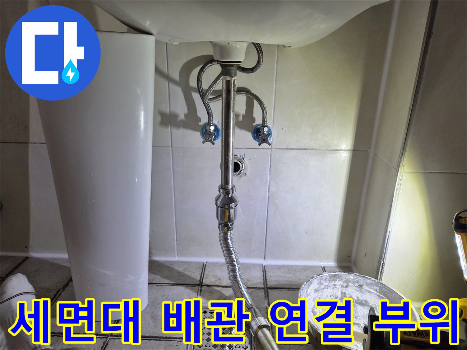 세면대 아래쪽 밸브와 은색 자바라 호스의 상세 모습
