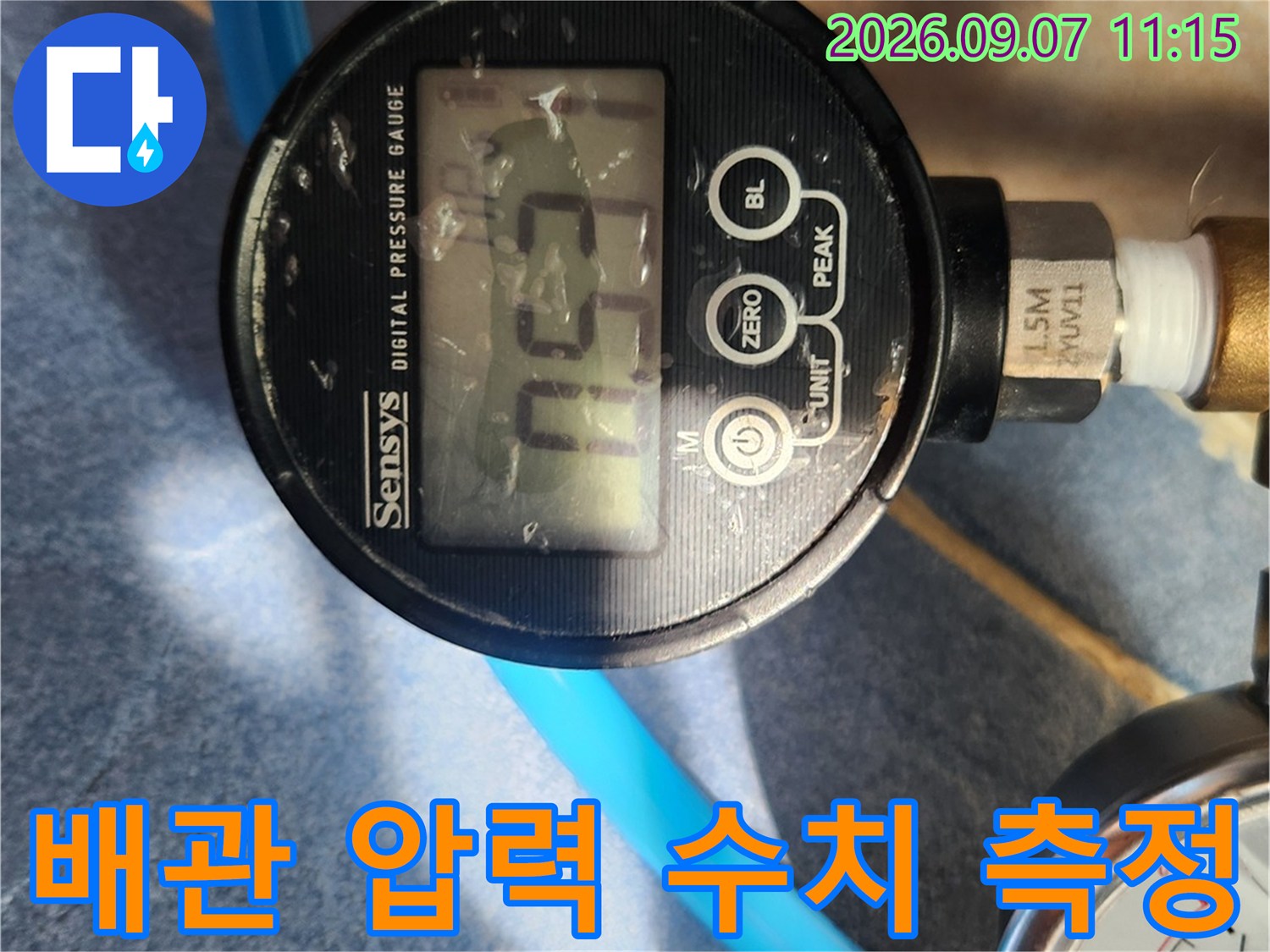 누수 원인을 찾기 위해 디지털 장비로 배관 압력을 정밀하게 측정하는 모습