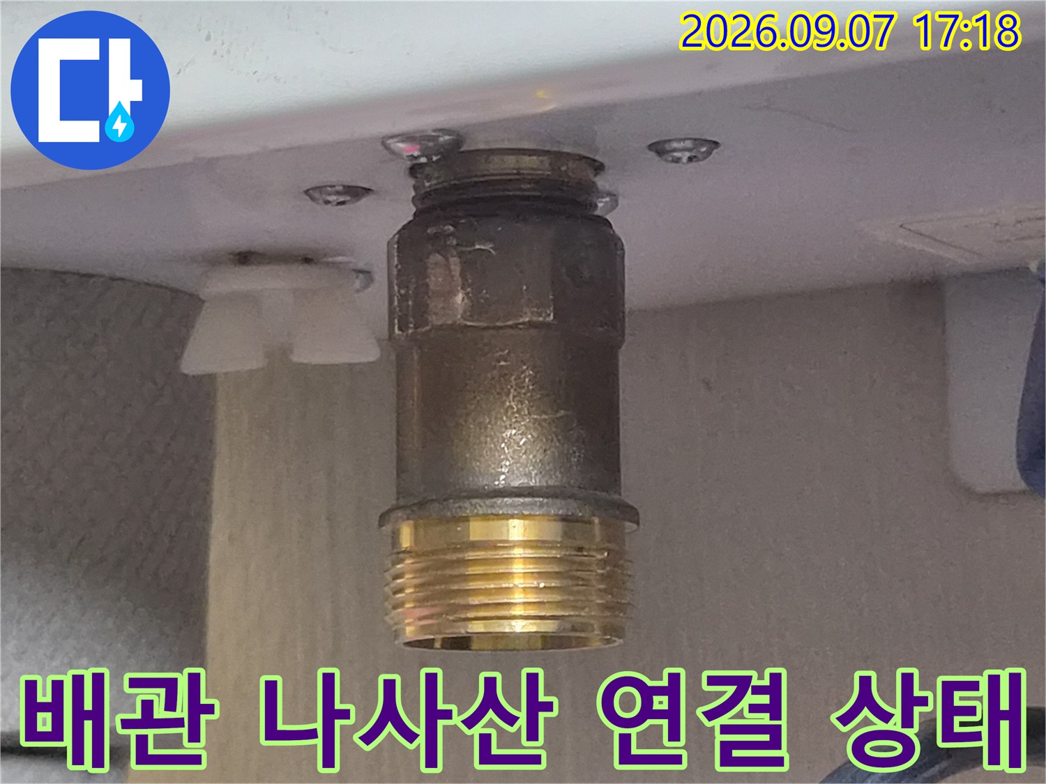 욕실 하부 배관의 금속 어댑터와 황동 부품 근접 사진