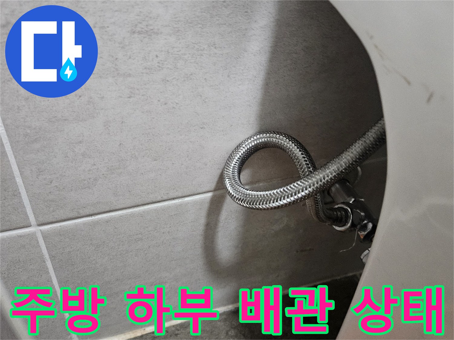 싱크대 밑 공간의 굴곡진 은색 자바터 호스 상세 사진