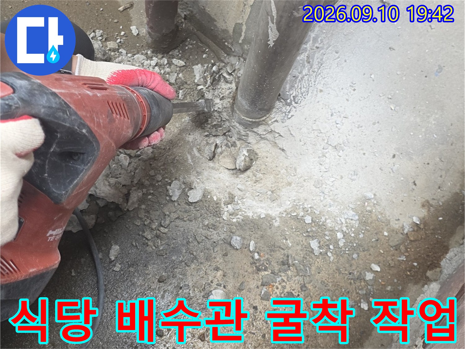 식당 내부 배수관의 누수를 잡기 위해 바닥을 파고 있는 공사 현장입니다.