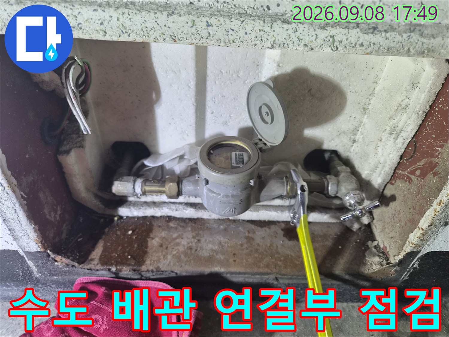 수도 계량기와 금속제 밸브 부근의 누수 여부를 정밀하게 관찰하는 장면입니다.