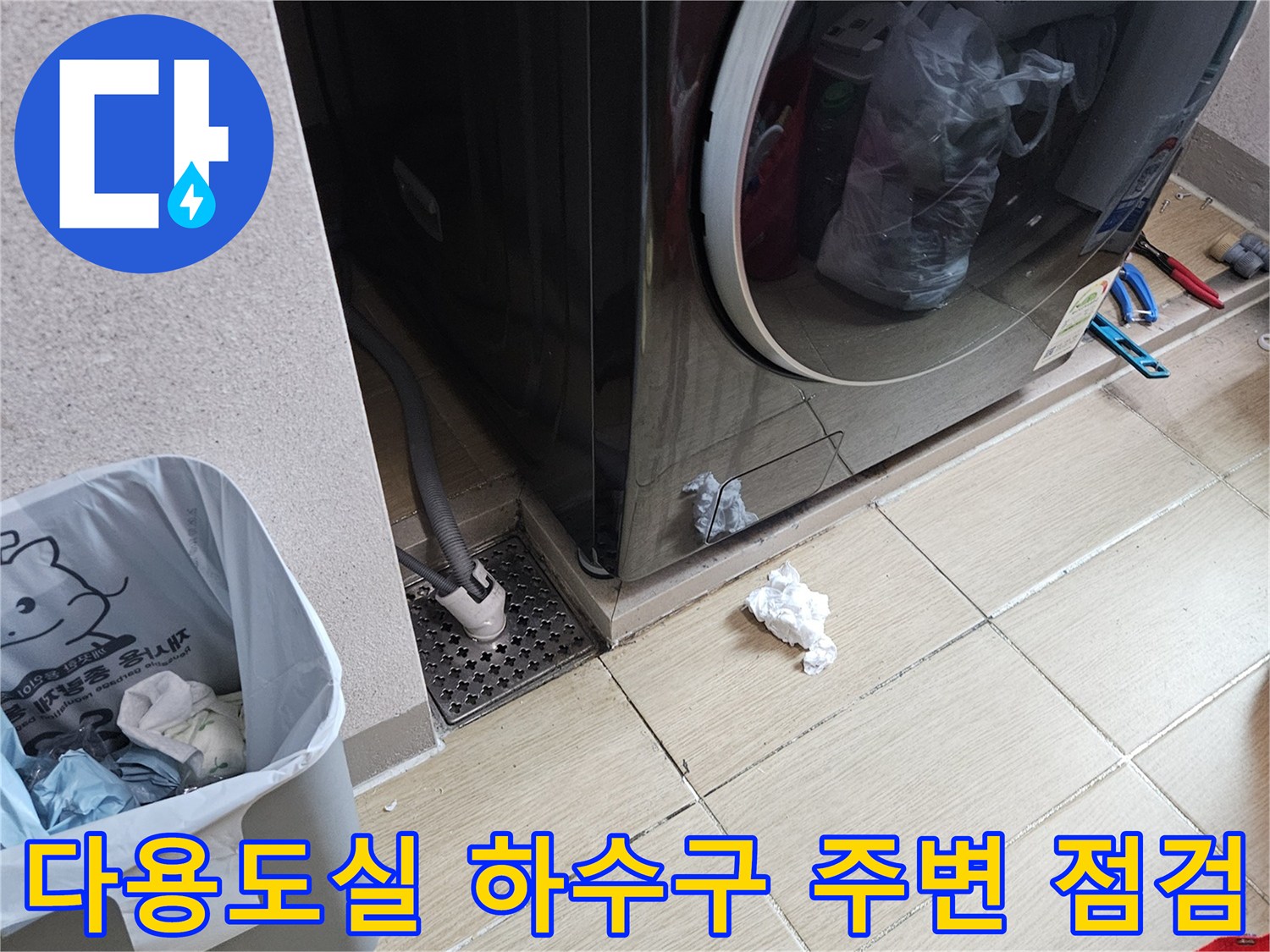 세탁기 옆 하수구와 연결된 배수 호스 모습