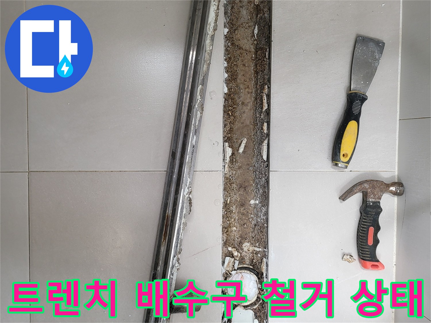 욕실 트렌치 배수구 주변의 타일을 제거하여 드러난 바닥면과 도구들