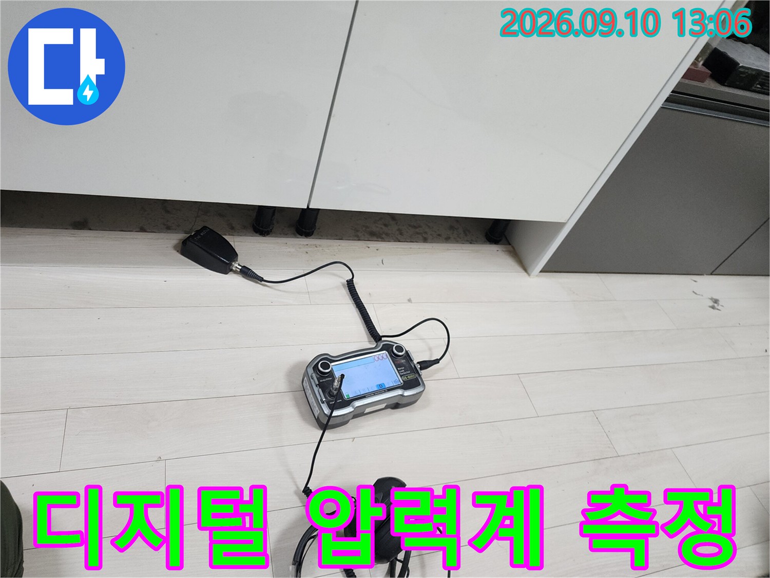 바닥에 놓인 디지털 압력 게이지와 연결된 청음식 탐지 장비의 모습입니다.
