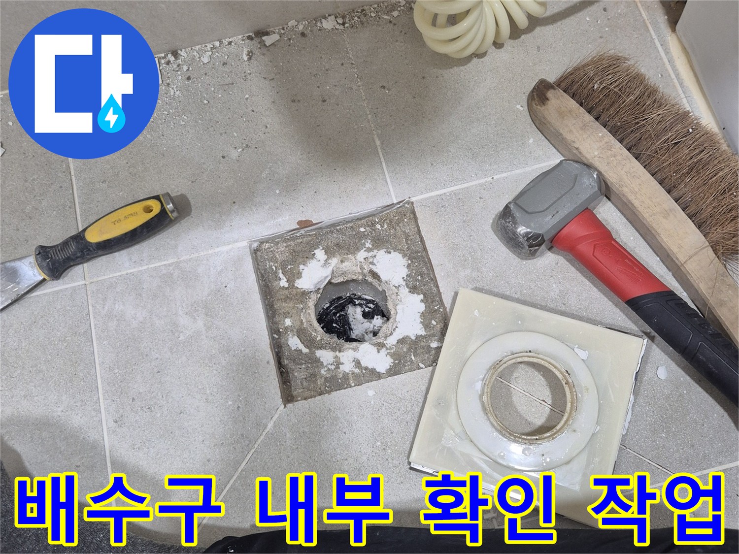 욕실 배수구 주변의 타일과 배관 상태를 확인하는 공사 현장 모습입니다.