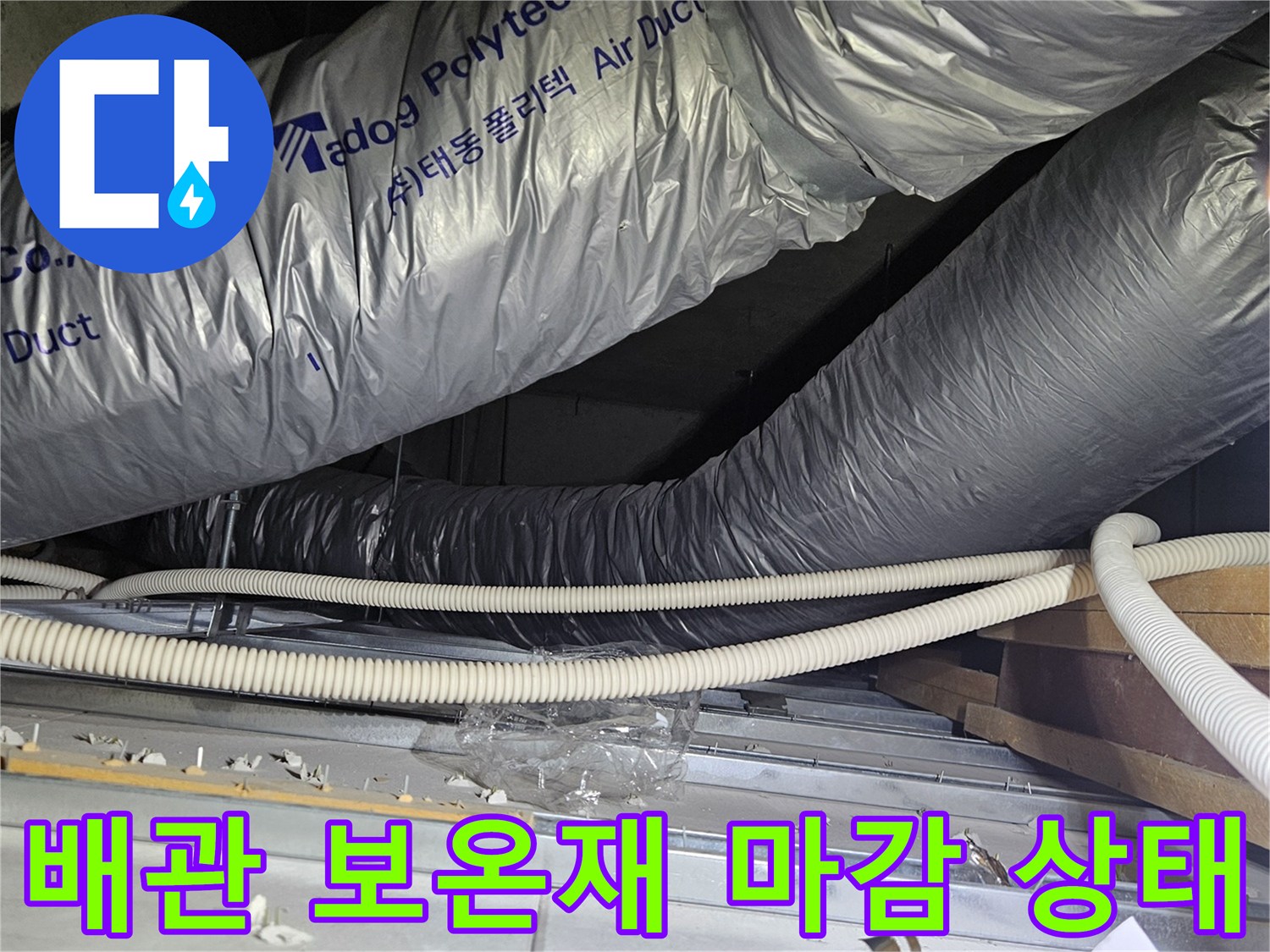 은색 보온재로 덮인 대형 배관과 옆으로 지나가는 유연한 배선 관로